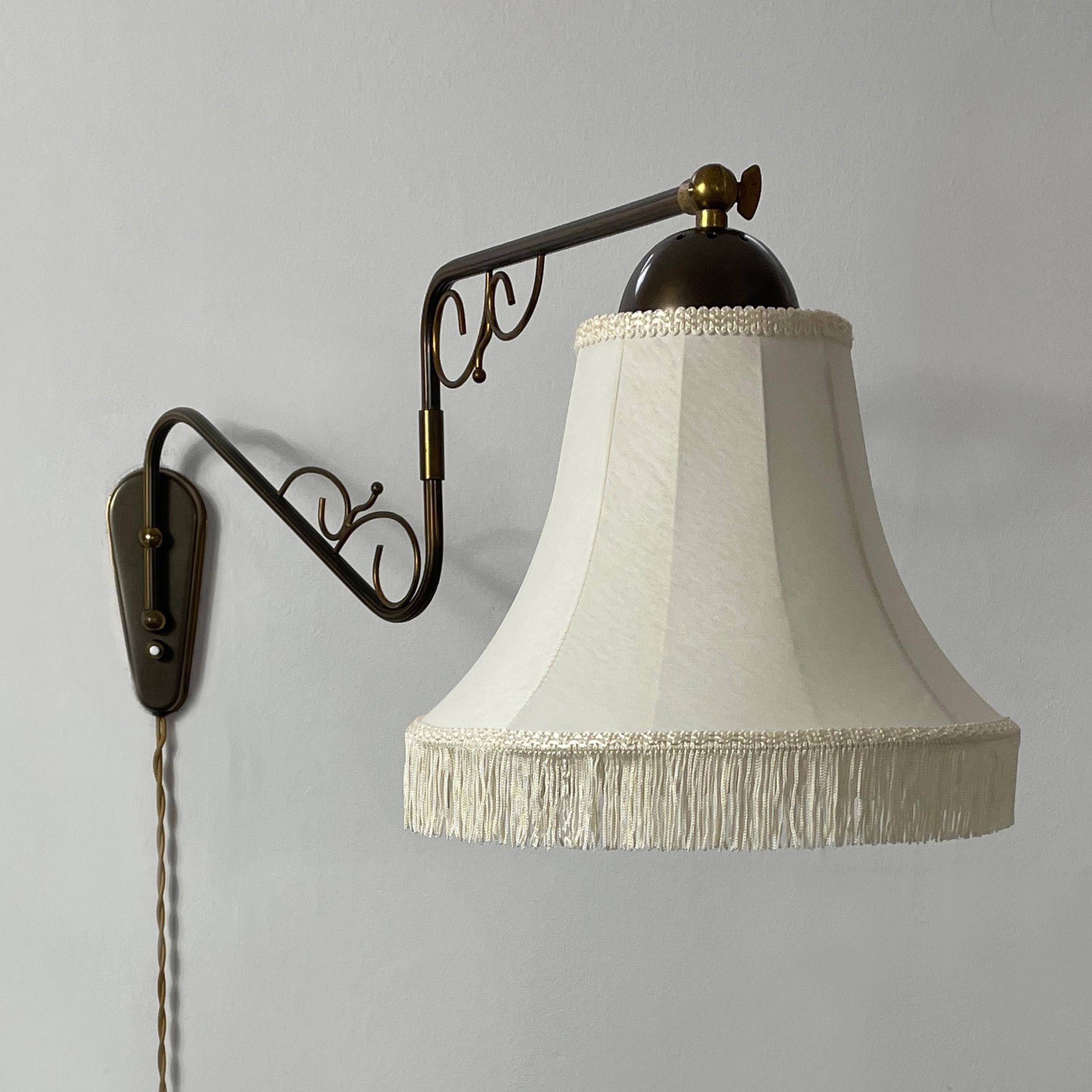 Applique murale de design suédois, années 1940

Le luminaire est doté d'un bras articulé extensible avec des volutes ornées dans une finition en bronze foncé antique, associé à un abat-jour classique en tissu crème en forme de cloche, orné d'une