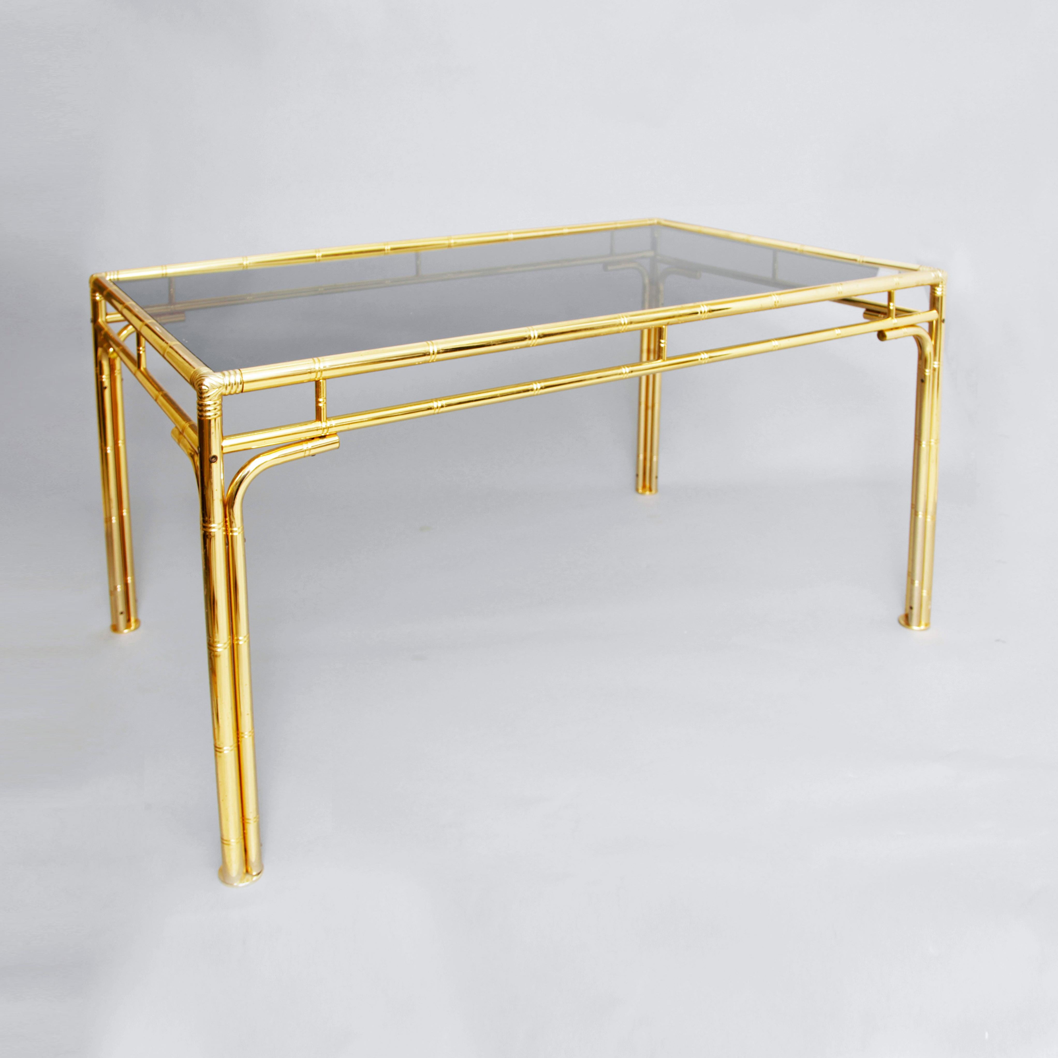 Elegant Hollywood Regency style brass faux bamboo dining table with smoked glass top.