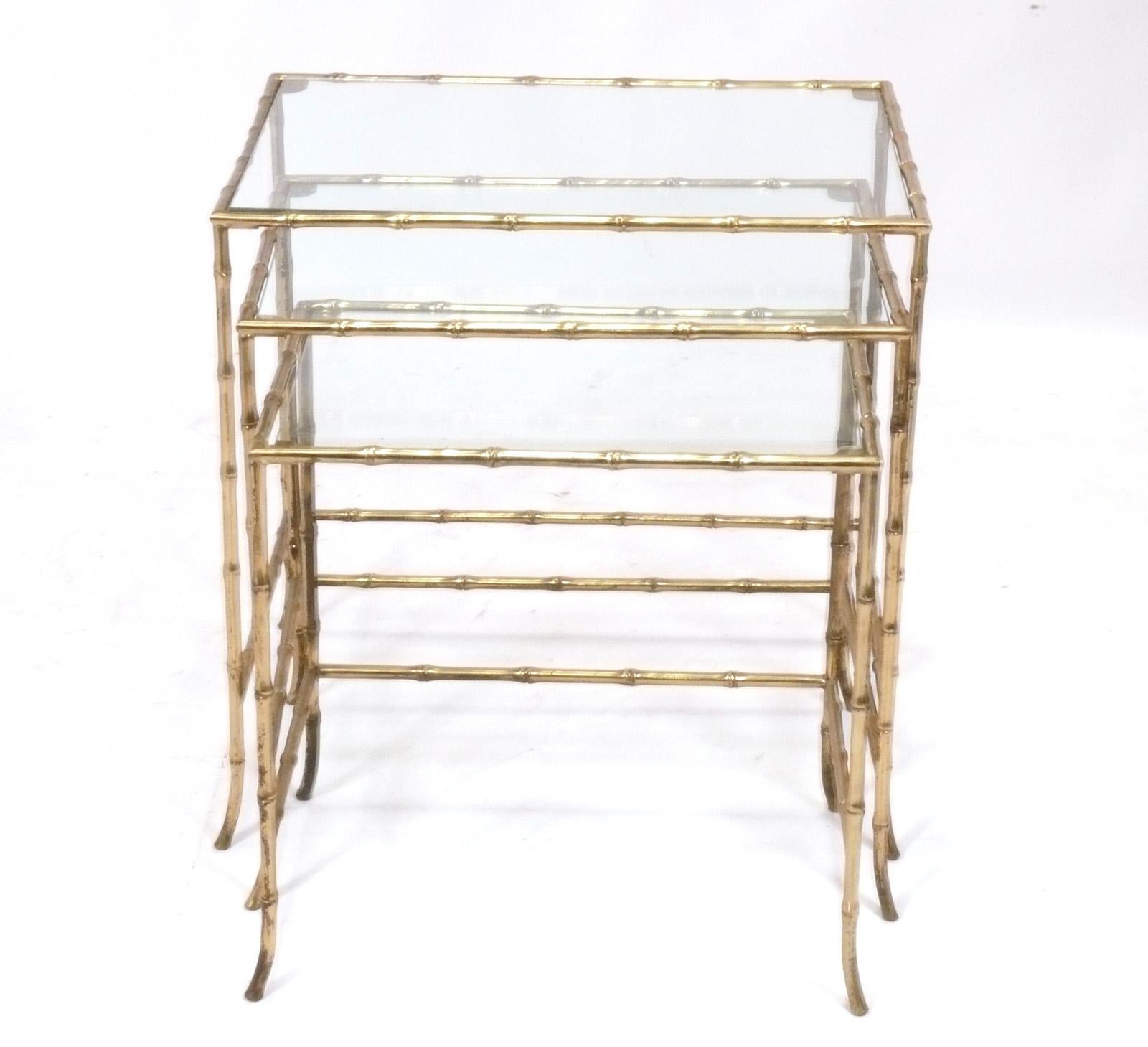 Elegant Set of Three Brass Faux Bamboo Nesting Tables, attributed to Maison Bagues, French, circa 1960s. Brass retains warm original patina. They are a versatile size and can be used as end or side tables in a living area, or as nightstands in a