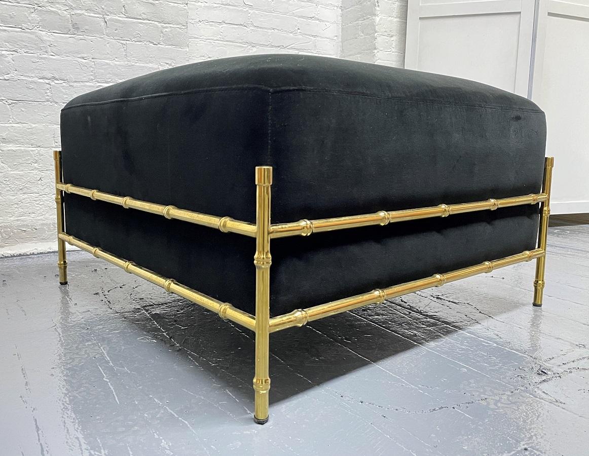 Brass faux bamboo ottoman. The ottoman is black velvet with a brass faux bamboo frame.