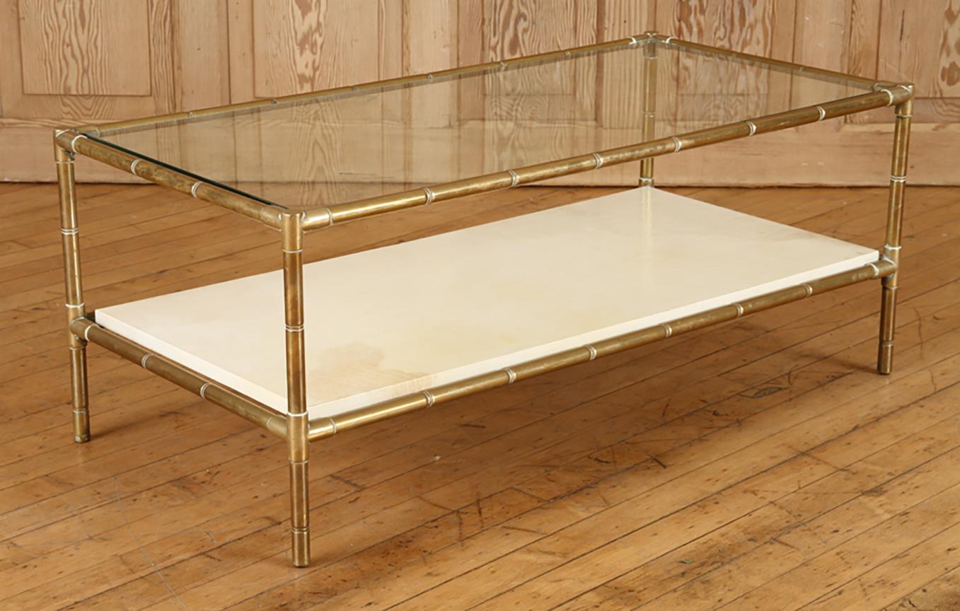 Brass faux bamboo two-tiered coffee table with parchment shelf.