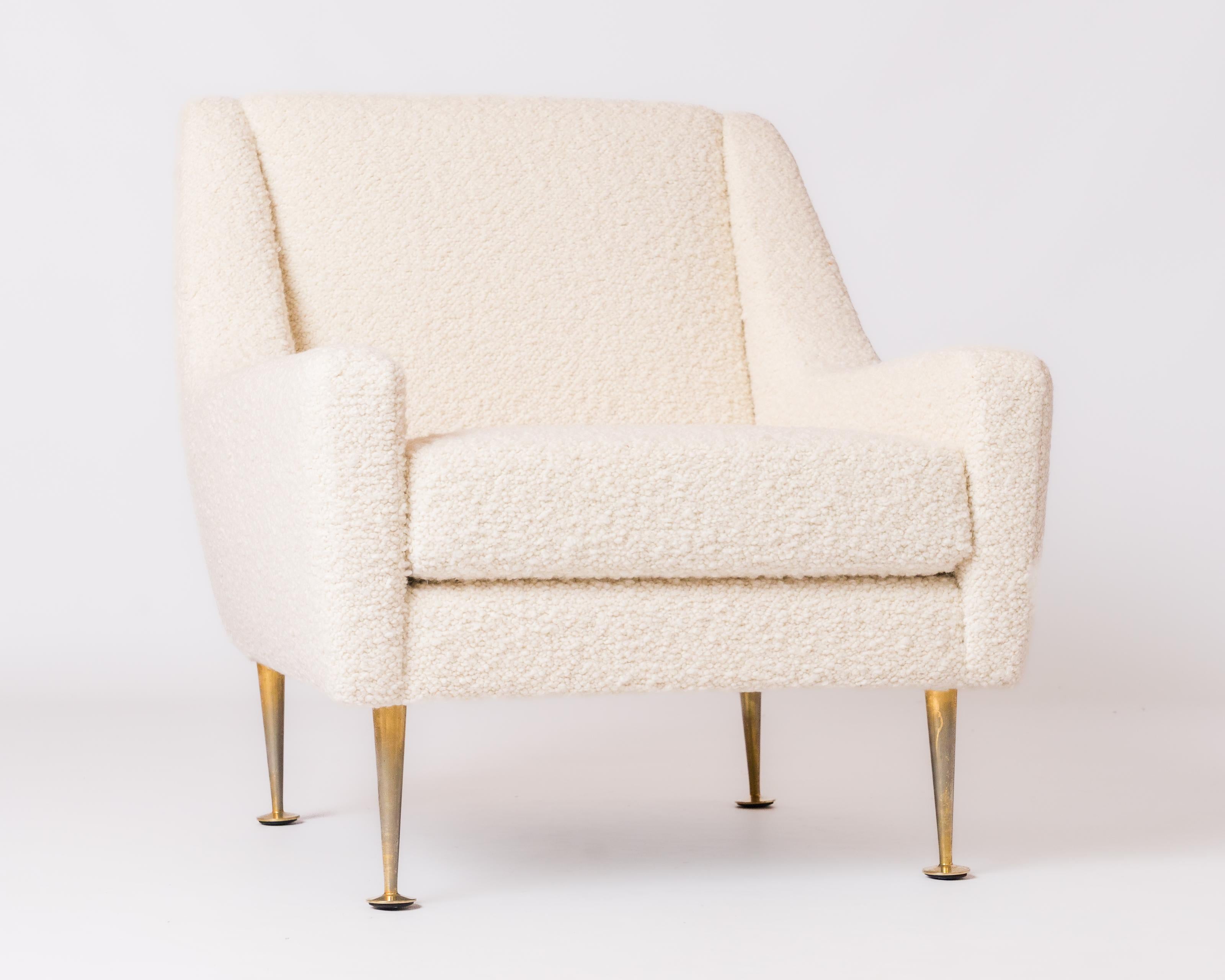 Elegant 1970's armchair by Airborne France.  Lounge type seating structure freshly re-upholstered with Designers' Guild iconic off-white bouclé mounted on four elegantly shaped brass feet.
This chair will ship from France and can be returned to