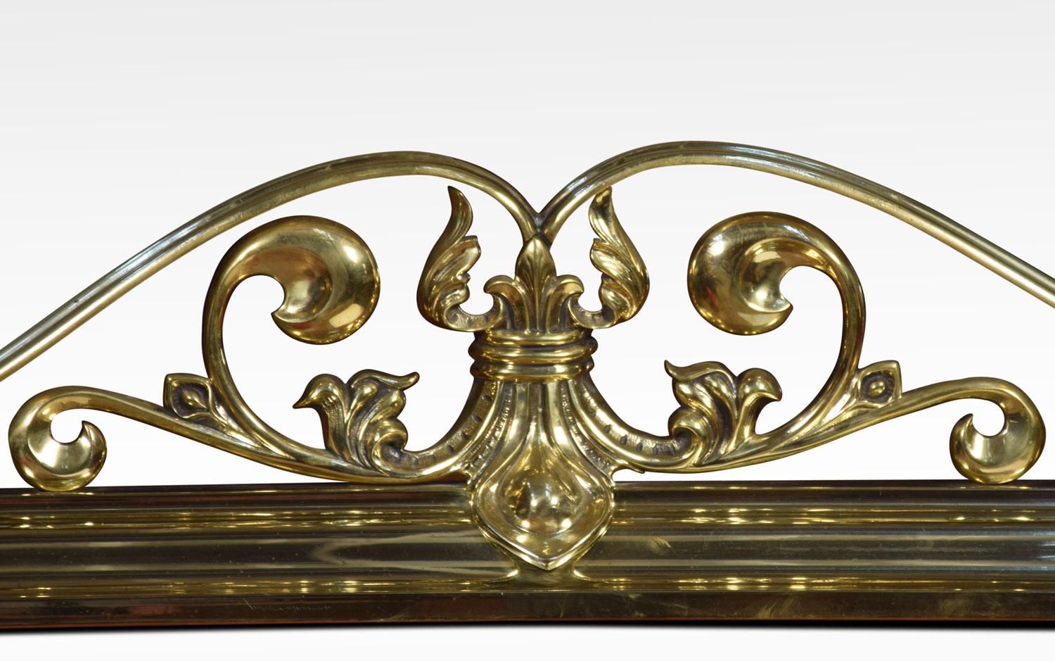 Brass fender, with pierced scrolling foliate crest, flanked to either side by raised scrolling finials.
Dimensions:
Height 12.5 inches

External measurements
Length 61 inches
Depth 12.5 inches

Internal measurements
Length 55 inches
Depth