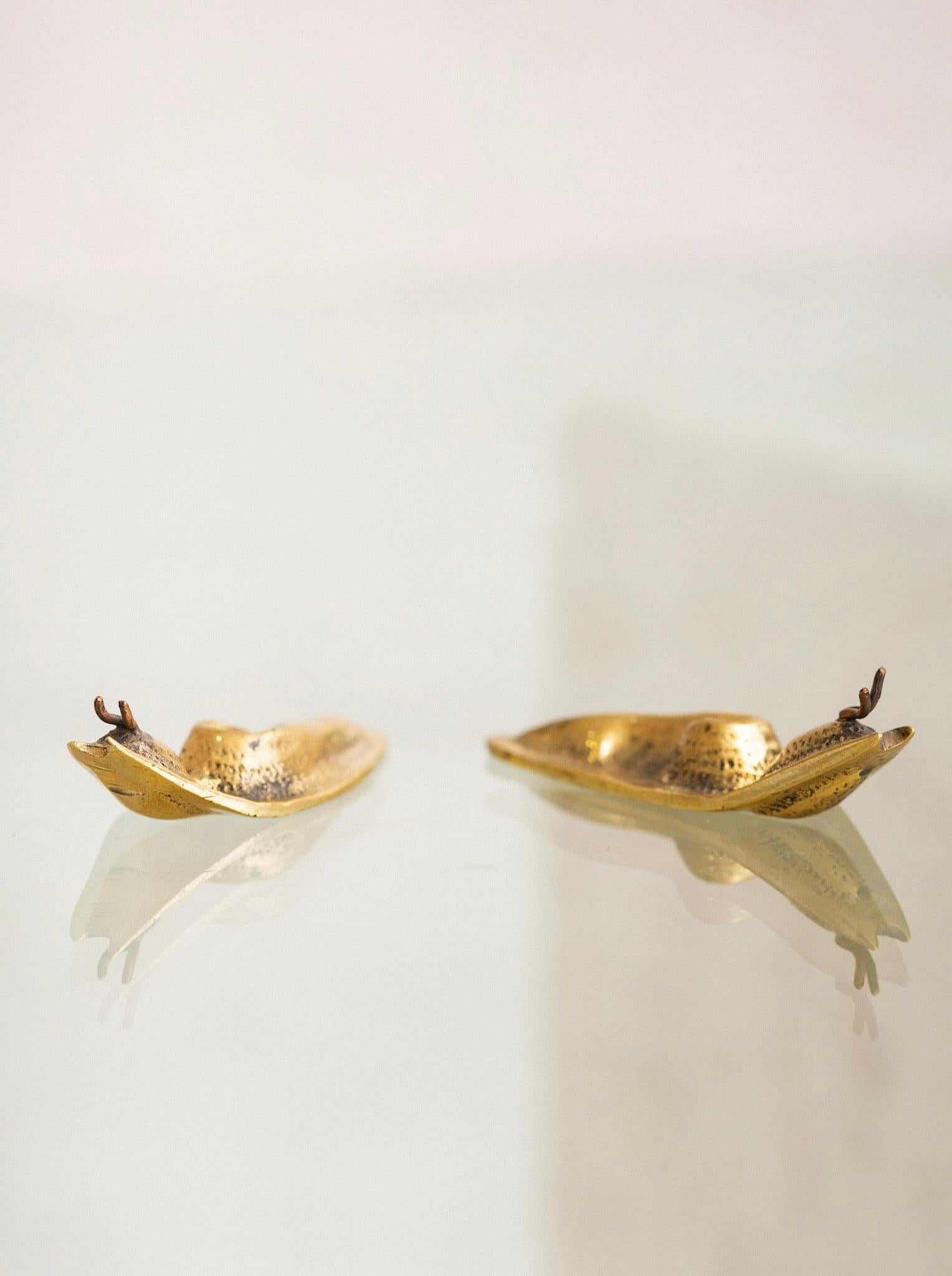 Pareja de objetos decorativos de latón en forma de babosa.
Las dimensiones son de cada pieza individual.