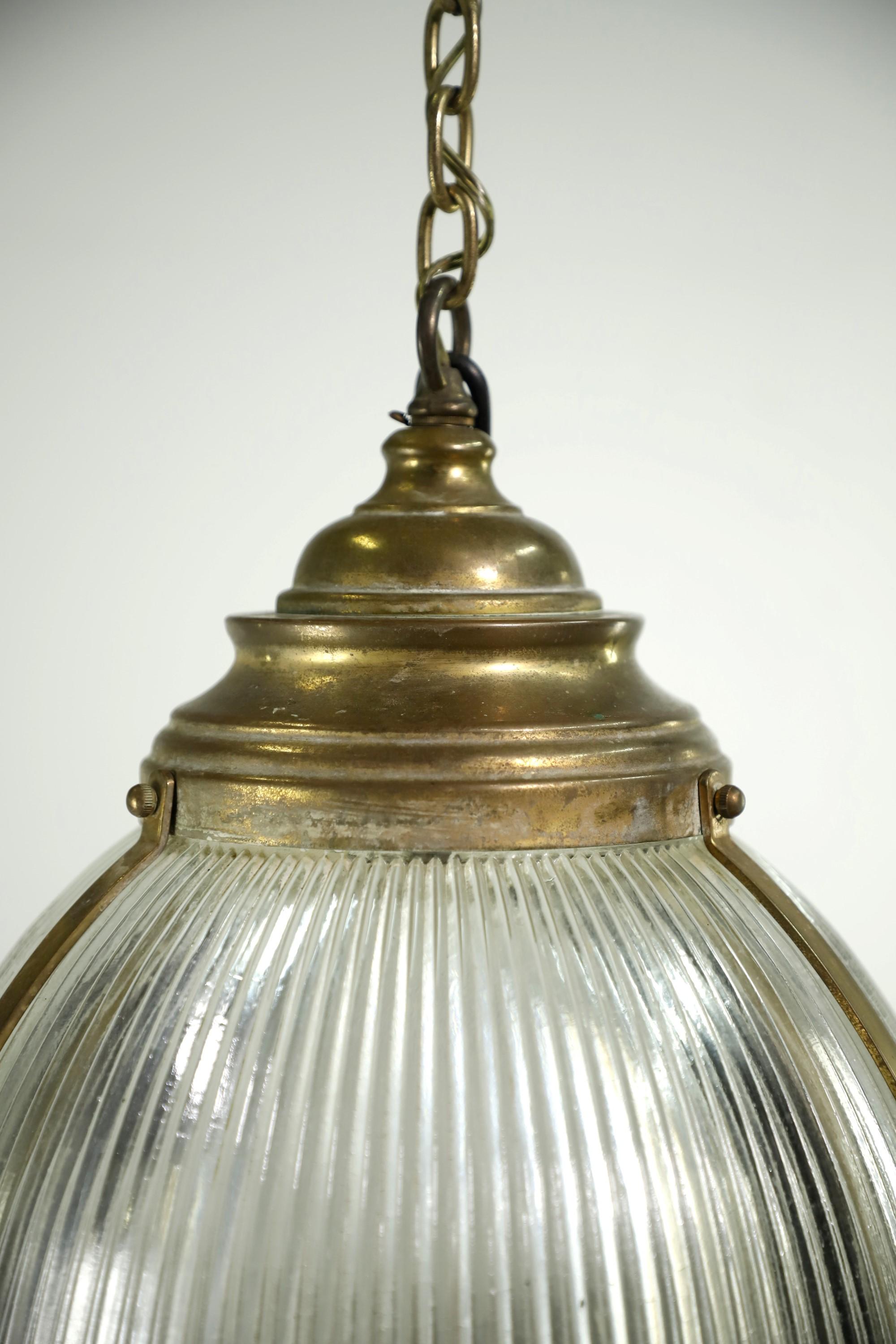 20th Century Holophane pendant light done in a brass finish. Shade features the classic ribbing pattern to spread out the light evenly. Takes one medium base light bulb. Cleaned and restored. Please note, this item is located in our Scranton, PA