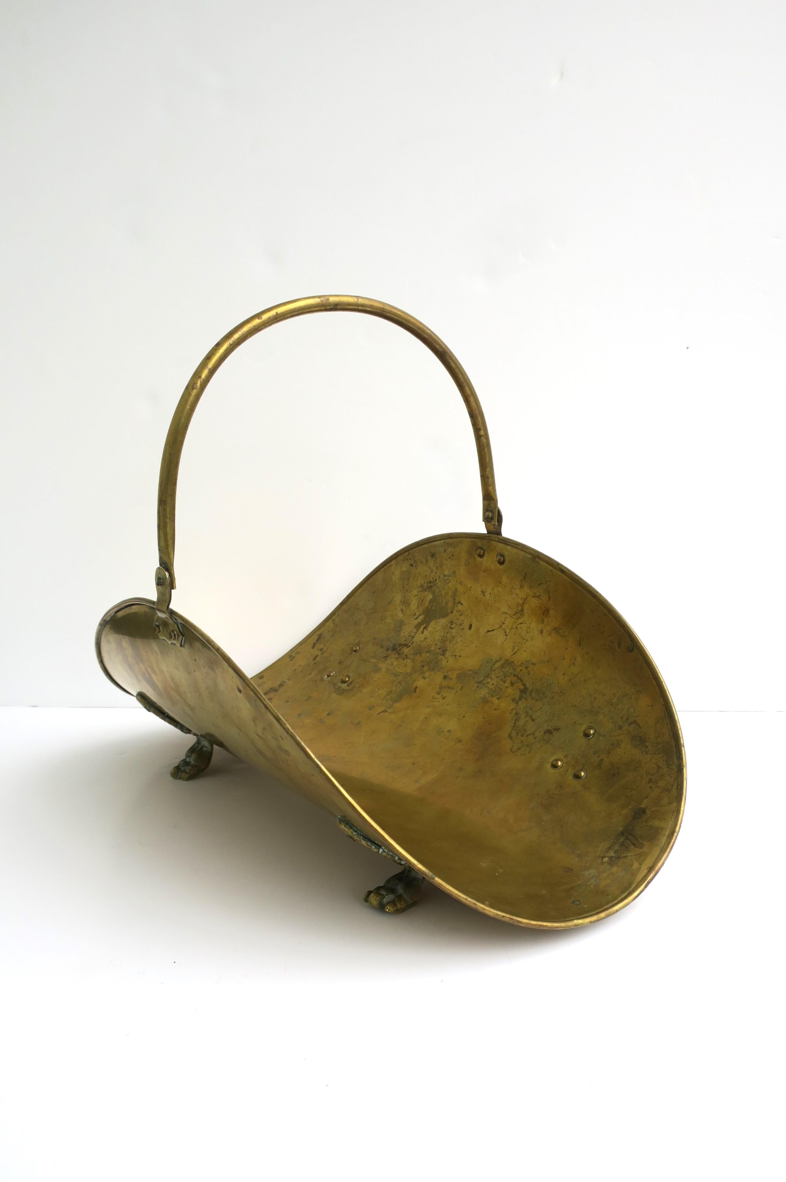 A brass firewood log holder with paw feet and adjustable handle, circa mid-20th century. Dimensions: 21