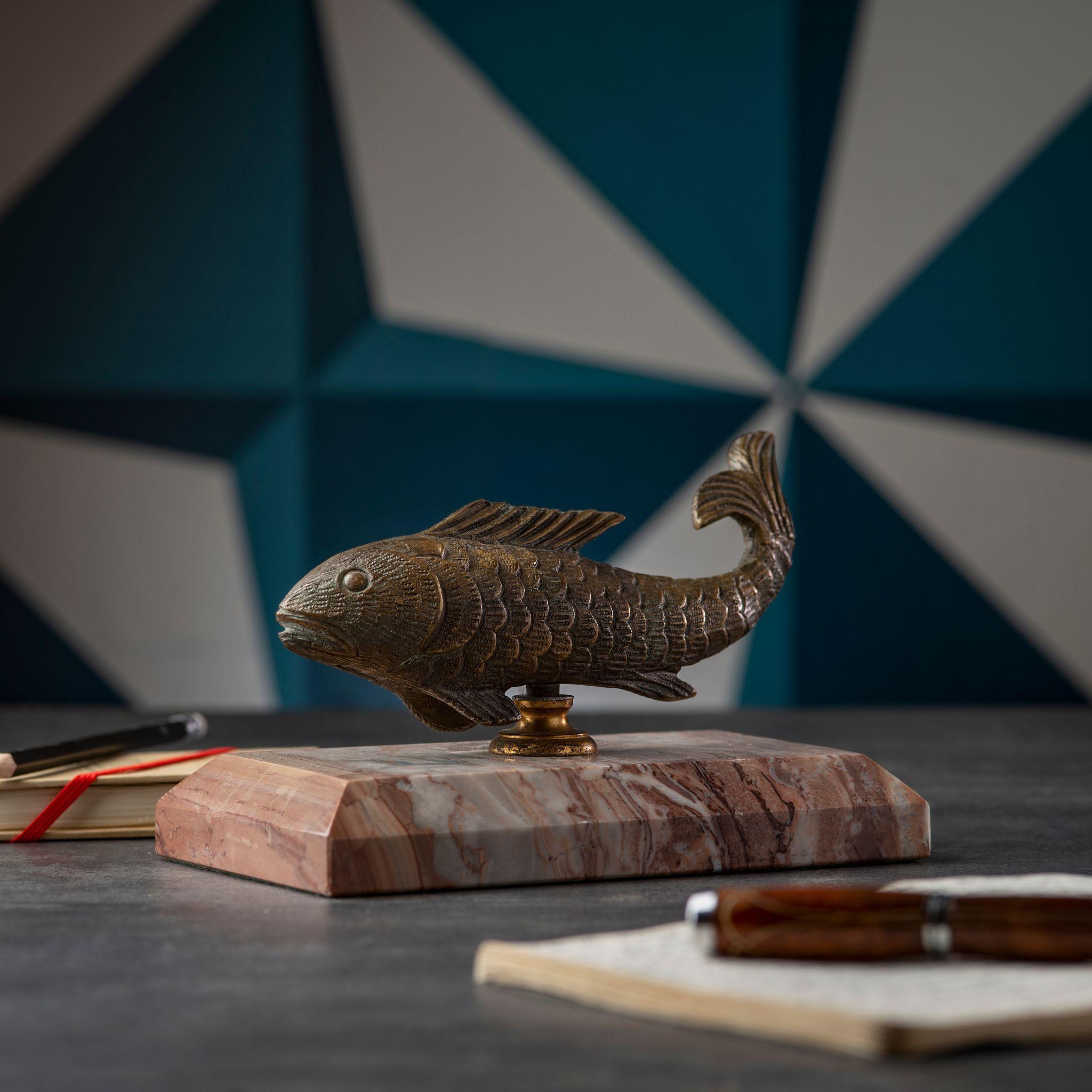 This stunning brass fish figurine with a beige marble base is a unique and eye-catching decorative piece. Handmade with care and attention to detail, this brass sculpture adds a touch of elegance and sophistication to any room. Its intricate design