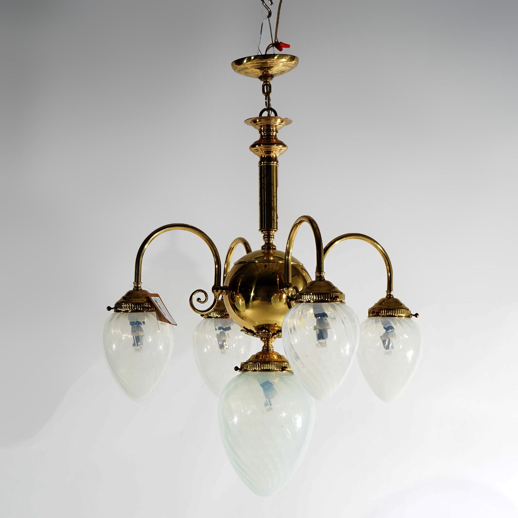 A drop-light chandelier offers brass construction with central light having oversized swirl tear form glass shade and four scroll form arms terminating in smaller matching swirl tear form glass shades, 20th century

Measures - 33