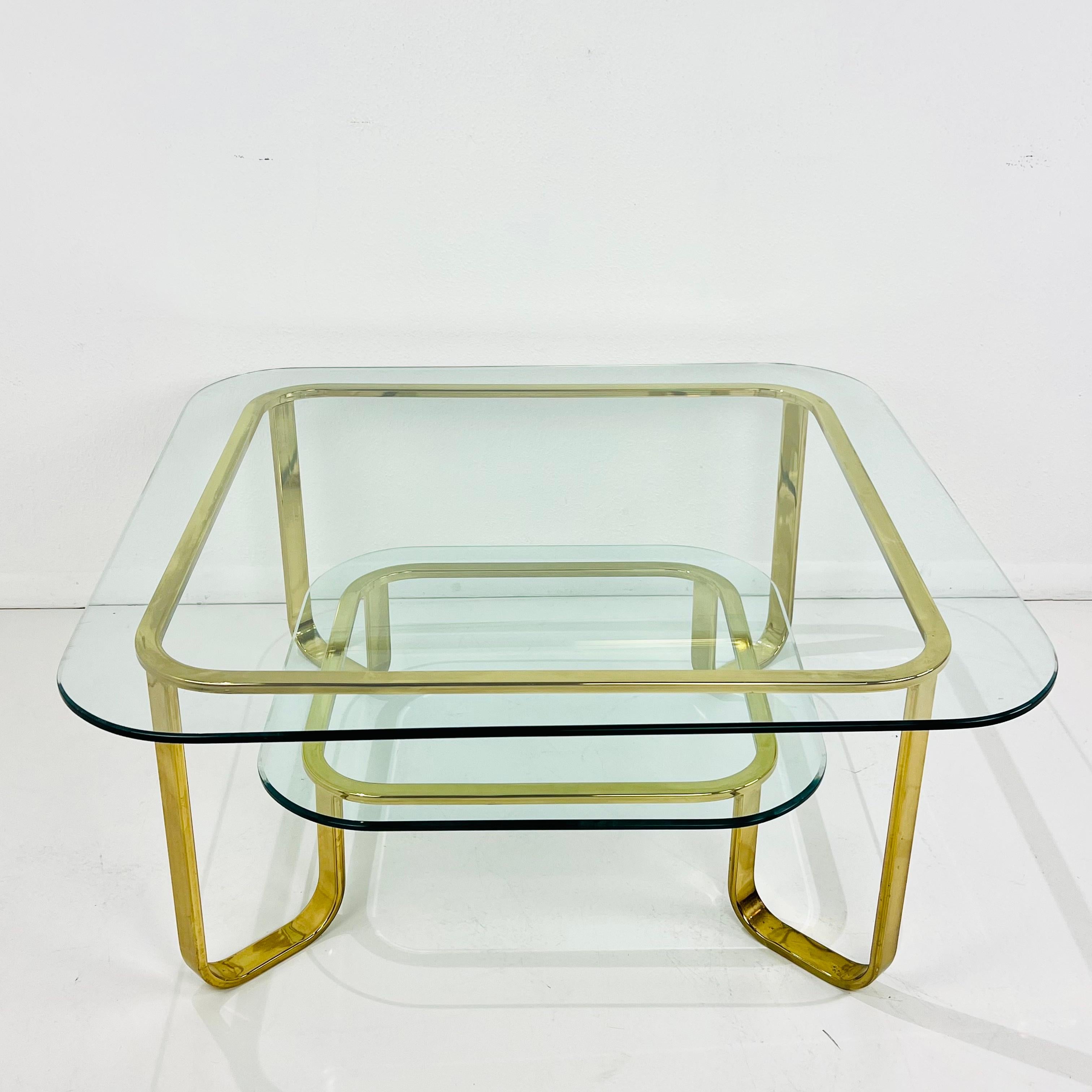 ¡Esta obra de arte escultórica inspirada en Milo Baughman es tan funcional como bella! Increíble mesa de centro de dos niveles, de metal chapado en latón y cristal. En buen estado vintage general, con algo de desgaste en el acabado de latón y un