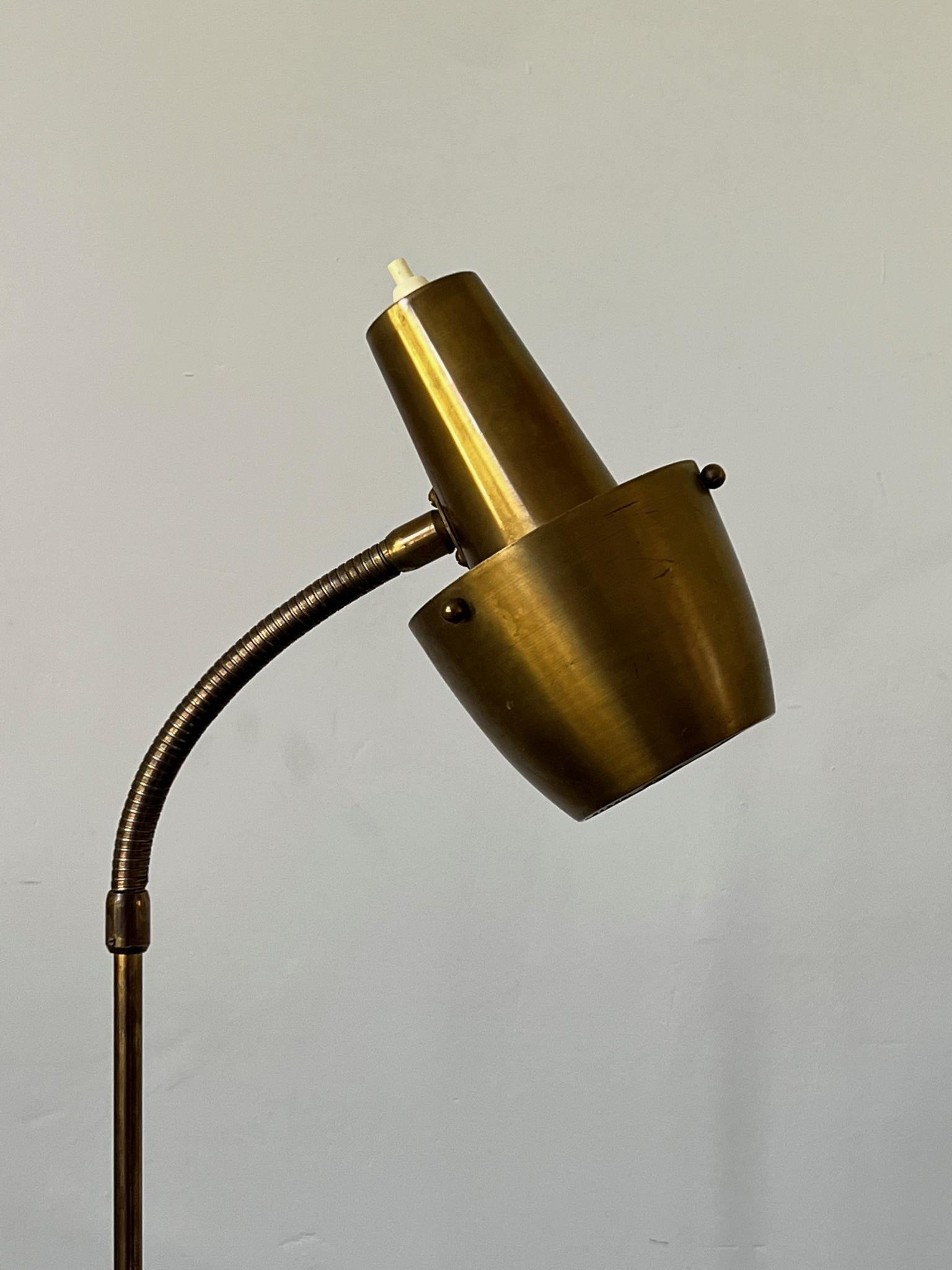 Brass floor lamp with adjustable neck and weighted base. Sweden, mid-20th century. 

A neat compact design in good original condition. There is with wear in line with age and use, including minor losses to the finish, light distortions to the round