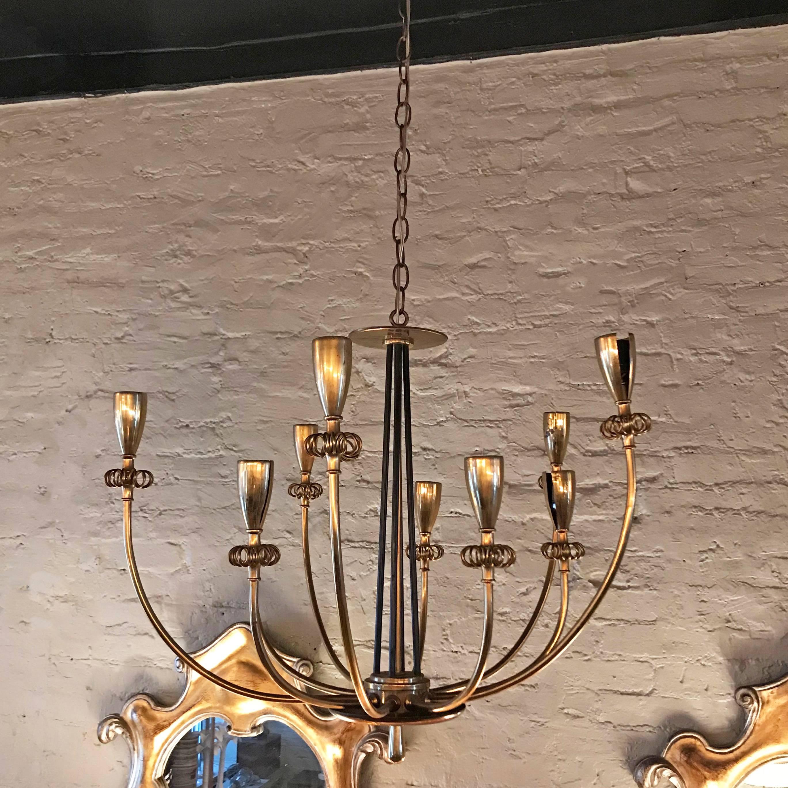 Elegant, brass, flush mount light fixture by Paavo Tynell features ten arms with floral bud tips that accept medium socket bulbs. The fixture is presently hanging on 40 inches of brass chain with canopy so it can be used as a height adjustable