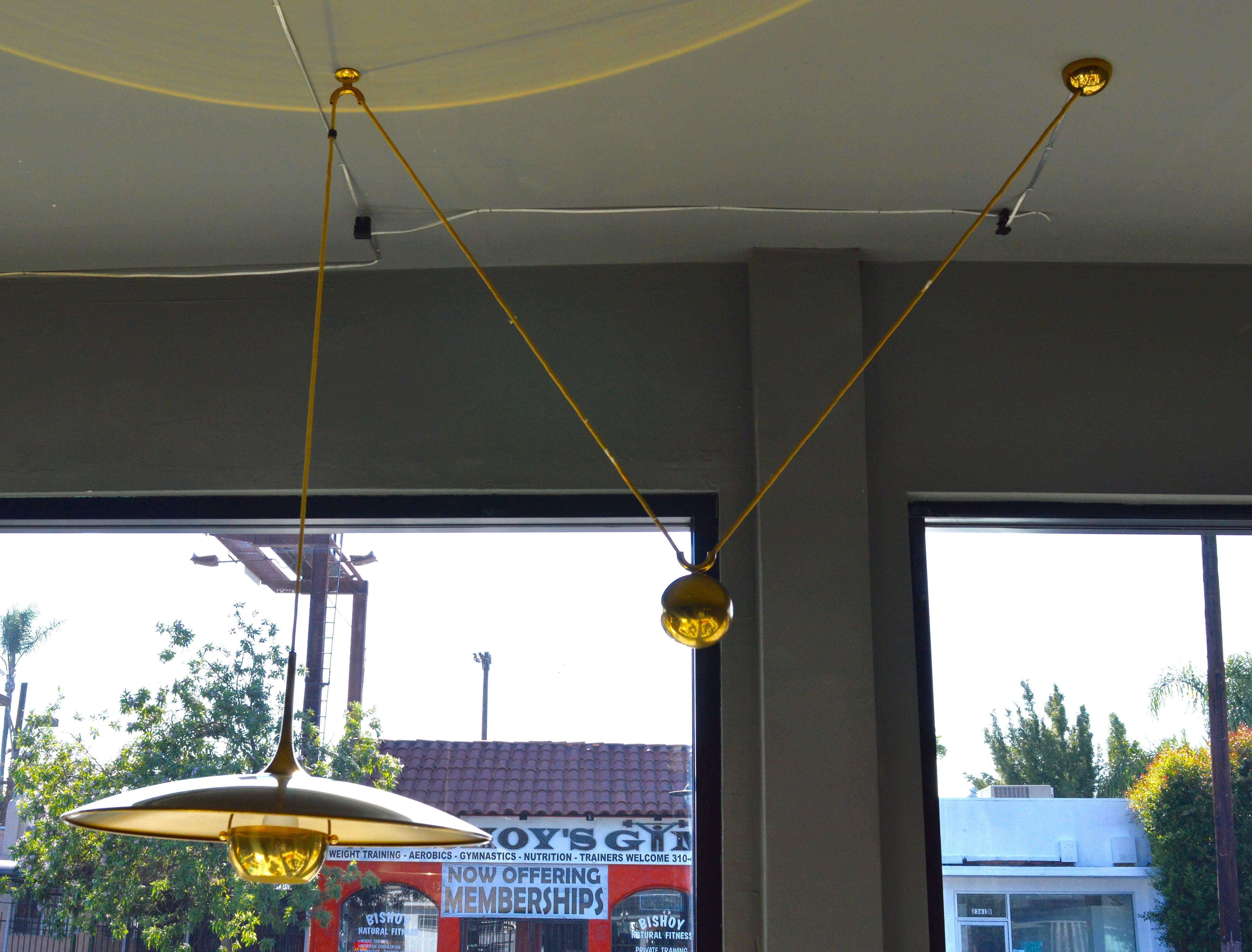 Handsome vintage counter balance pendant by German design house Florian Schulz. Brass hardware throughout with excellent patina. Brass canopy, brass counter-weight, brass diffuser and black cloth cord. Overall height is easily adjustable from 16