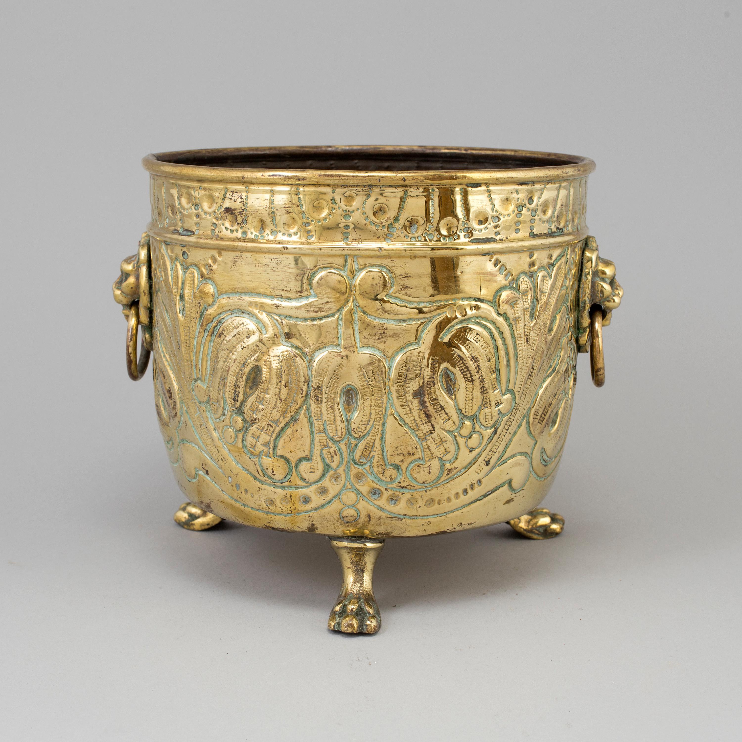 French flower pot in brass with lion motifs.