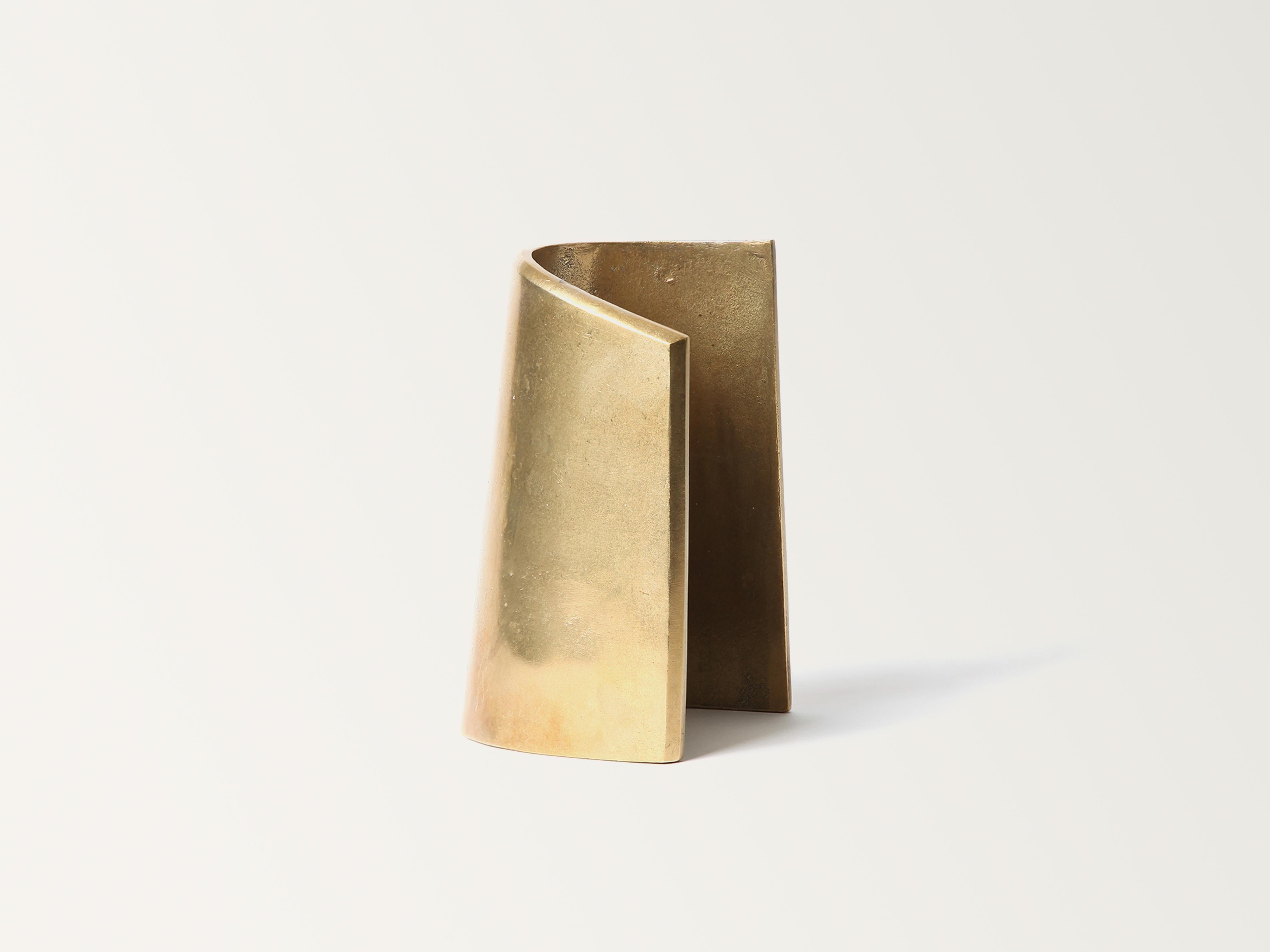 Brass Fold Bookend by Stem Design
Dimensions: D 11 x W 11 x H 18 cm.
Materials: Brass.
Finish: Tumbled and burnished.
Weight: 2,5 kg.

Finished and assembled by hand in India. Please contact us. 

Fold bookend captures the recurring act of turning a