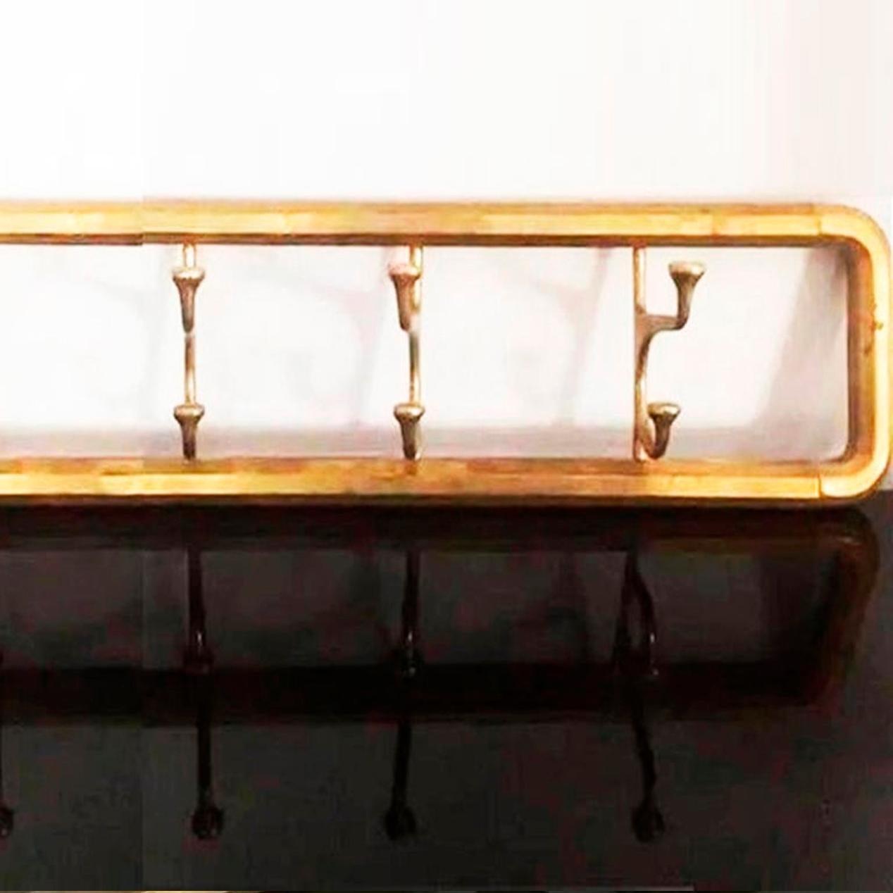 Midcentury / Art Deco foldable wall coat rack in brass or bronze 

Foldable with four hangers
It is a solid piece of brass or gilt bronze, not a sheet metal. Excellent condition.