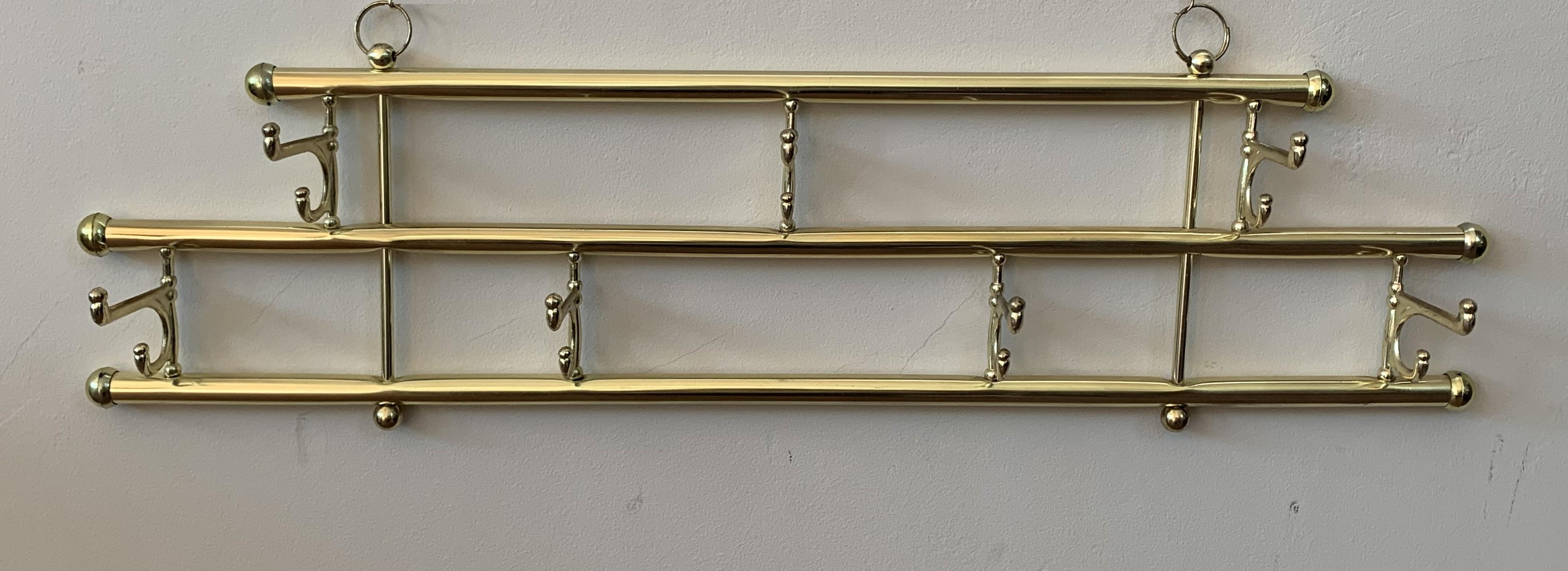 Midcentury / Art Deco foldable wall coat rack in brass

Foldable with seven hangers

Very good vintage condition.