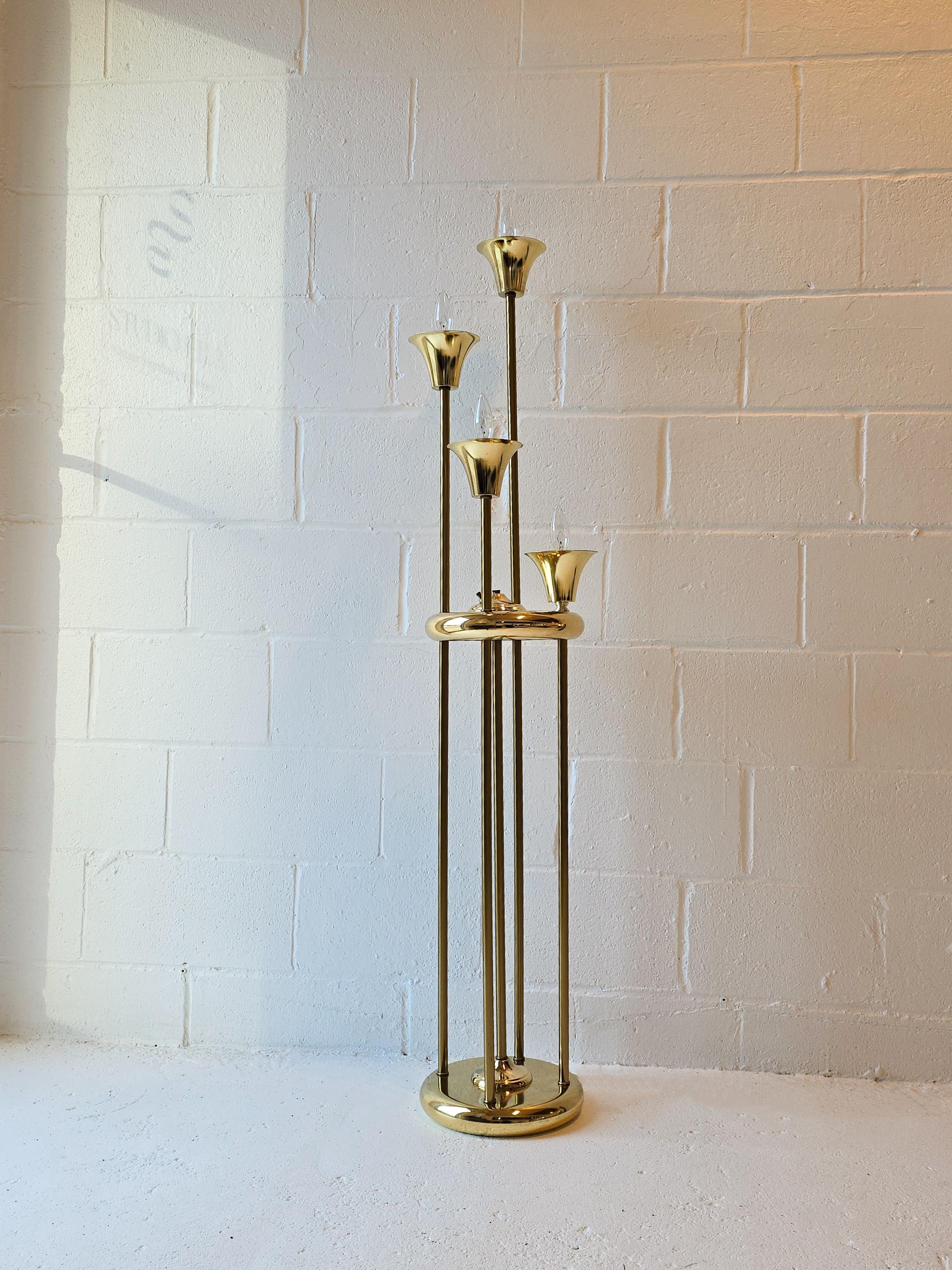 Lovely brass plated candabra style four tier floor lamp. This floor lamp features four tiers all at different varying heights. There's a circular base and a circular mid section where all of the tiers connect through. The top of each tier has a