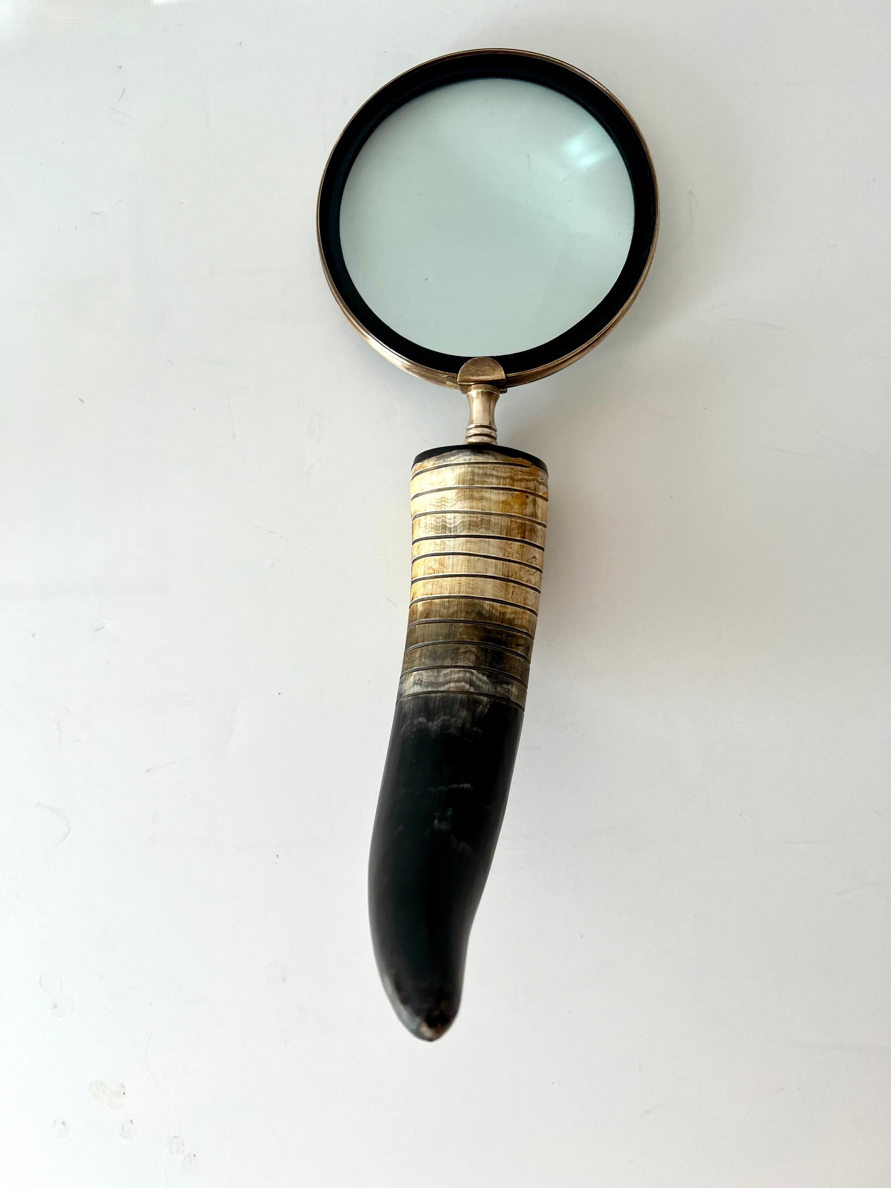 Horn Handle desk style magnifying glass with brass framework and stem. The horn is quite substantial and has good weight and presence.

The horn has a ribbed detail down a portion of the handle. A compliment to any desk or work station, especially