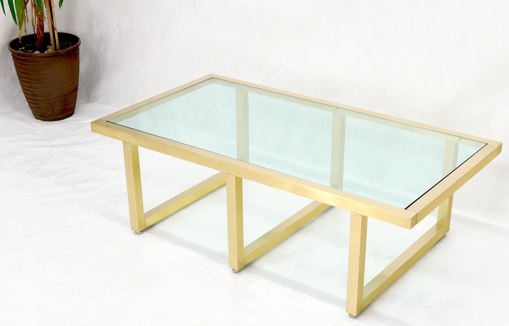 Heavy gage bolted together machined brass frame glass top coffee table.