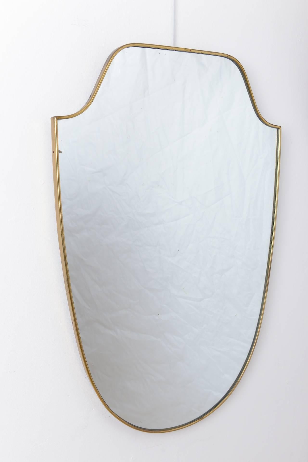 Nice quality brass framed mirror in shape of a shield, Italy, circa 1950.