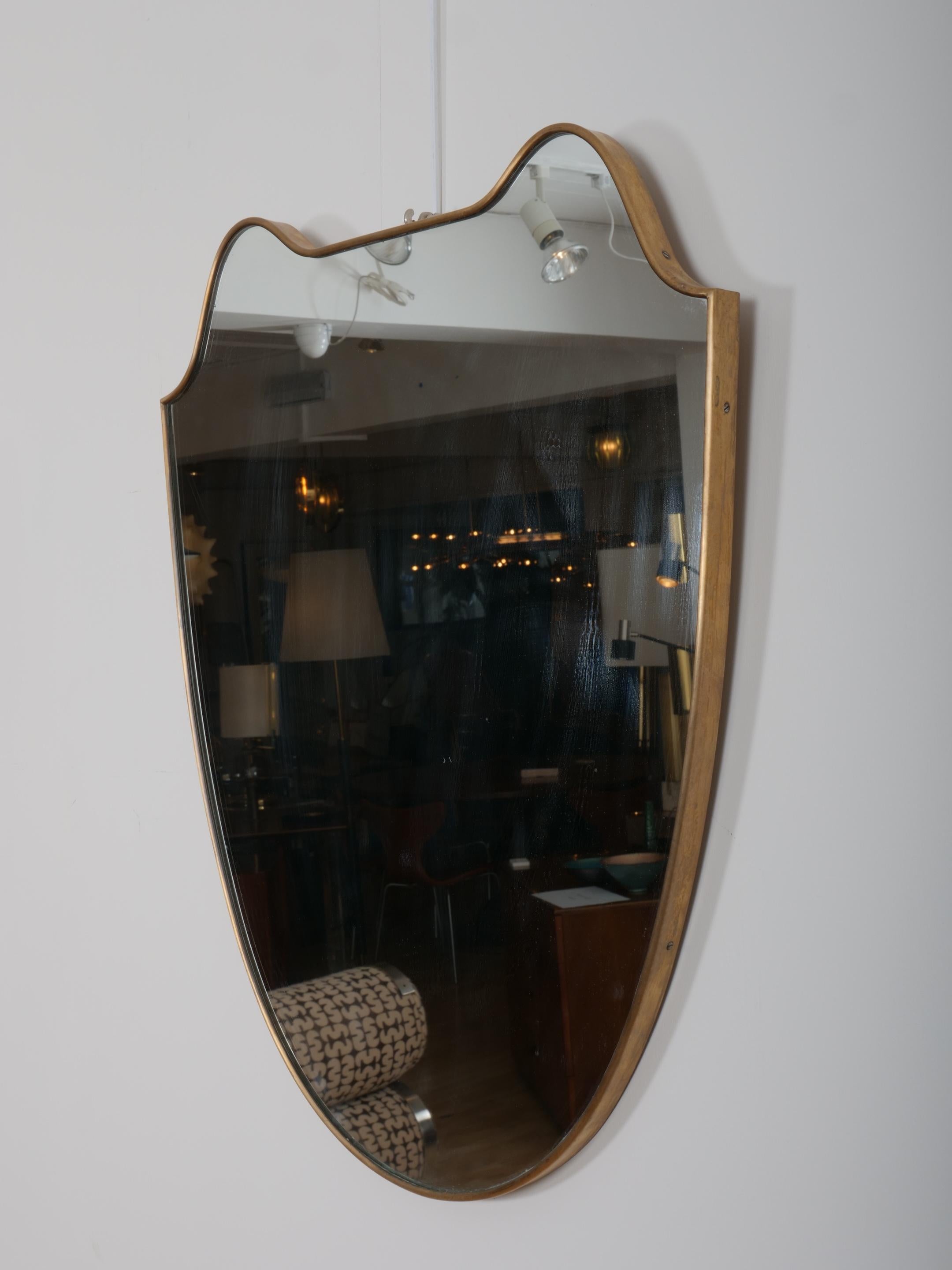 italien Miroir en forme de bouclier avec cadre en laiton. Italie c1950 en vente