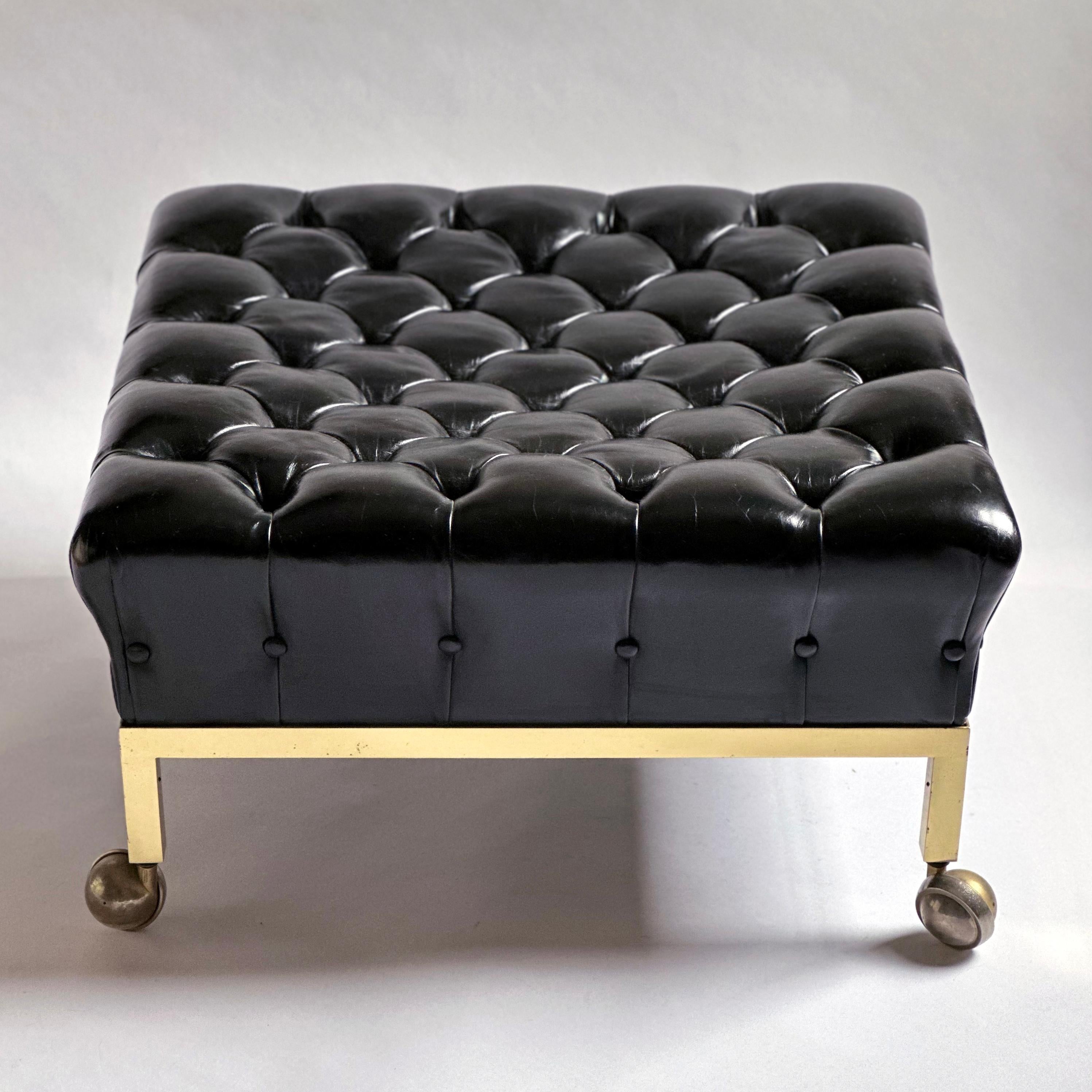 Square, brass-framed ottoman on casters with its original biscuit tufted, black leather upholstery, designed by Harvey Probber. 1960s.