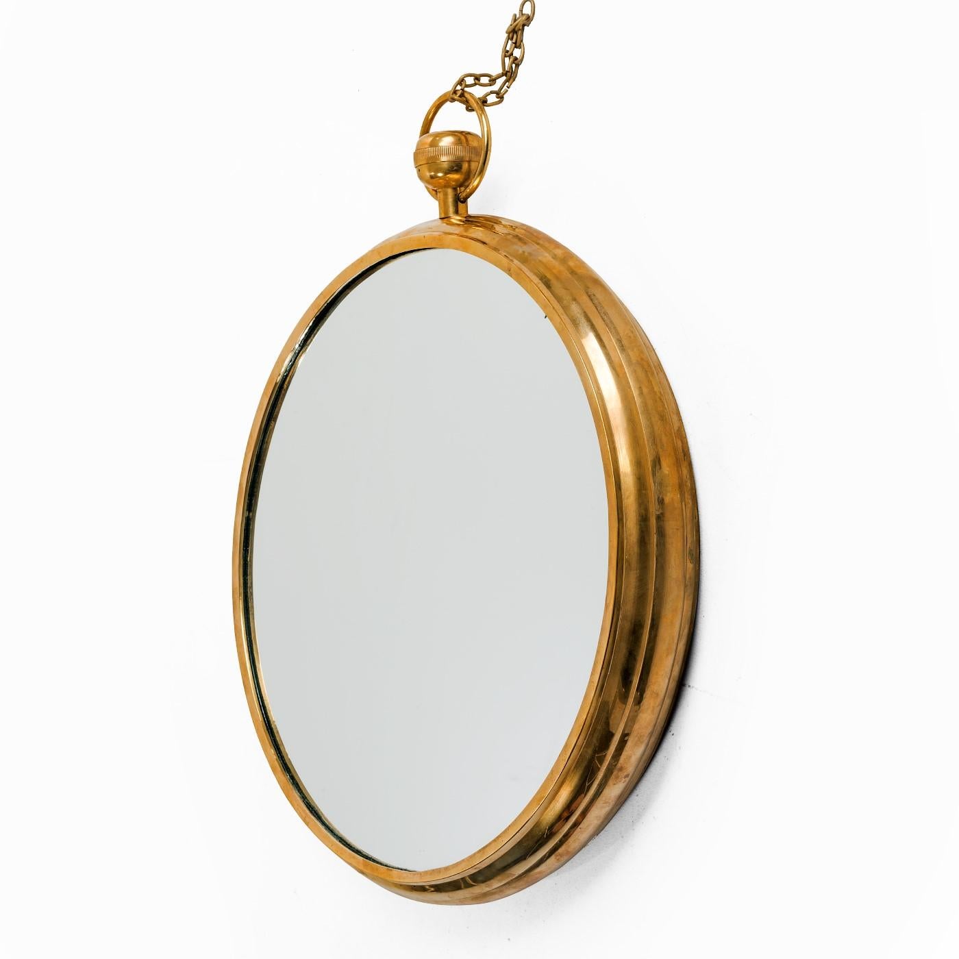 Mirror with heavy brass frame in the manner of Fornasetti.