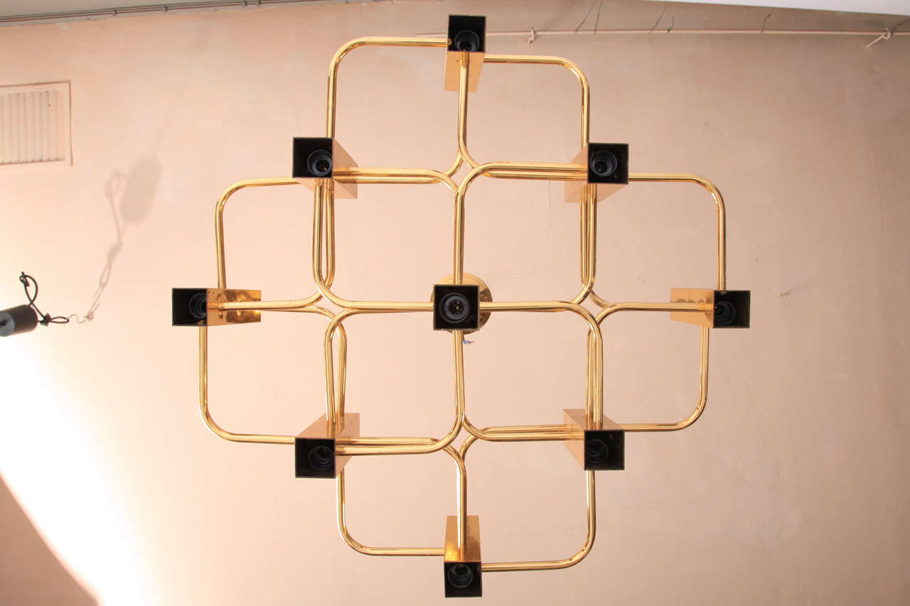 A stunning modernist chandelier Boulanger chandelier designed by Gaetano Sciolari in brass with 9 brass cubes lights surrounding a center support that form a geometrical pattern. Each light fitting can be pushed inside its frame to suit different