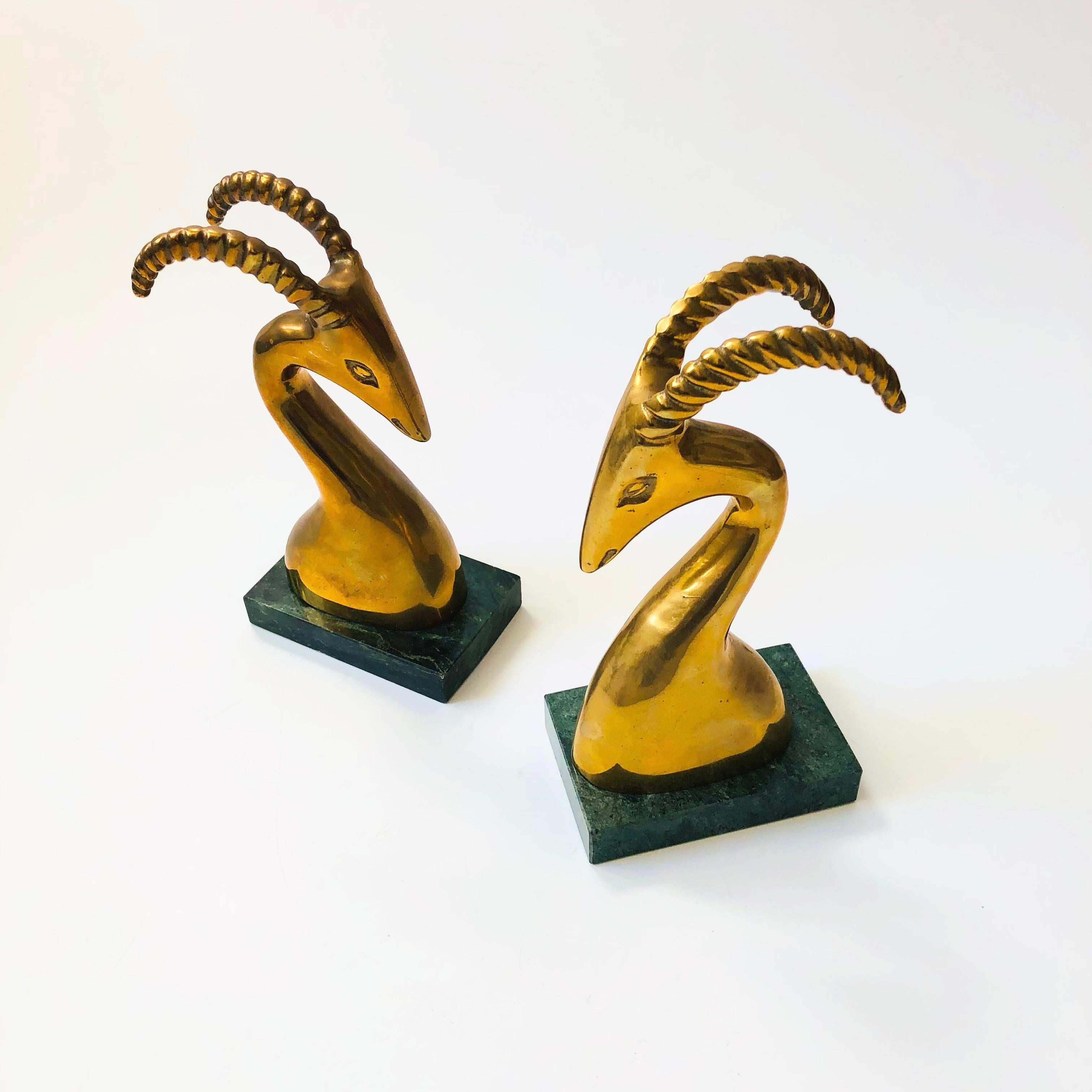 A pair of vintage brass bookends in the shape of gazelles. Beautiful gold patina and green stone bases. Great stylized deco design.

