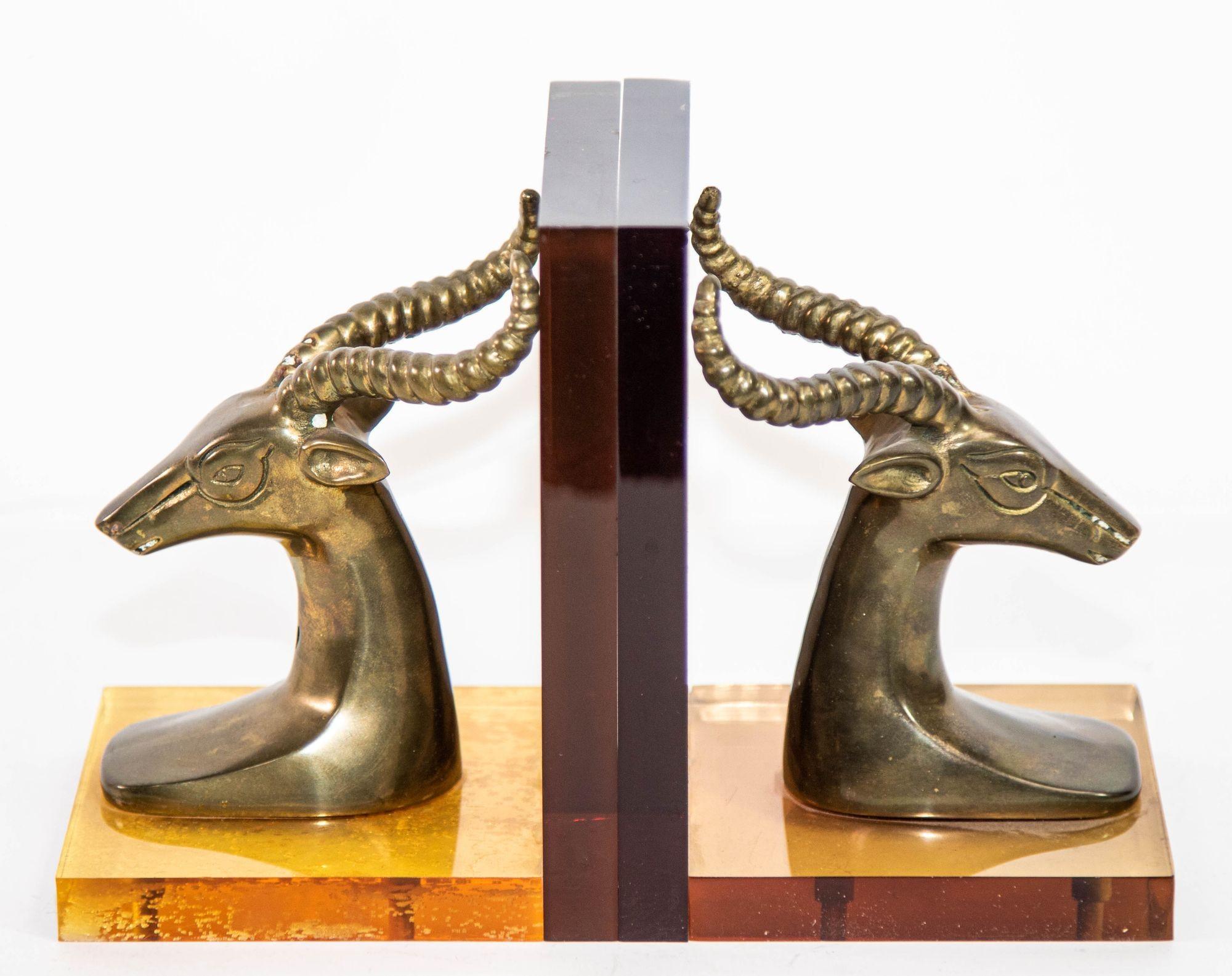 This exquisite pair of Art Deco Revival brass gazelle bust bookends, mounted on amber Lucite bases, embodies the elegance of Hollywood Regency style.
Crafted in the 1950s, these polished brass gazelle antelope heads serve as both functional bookends