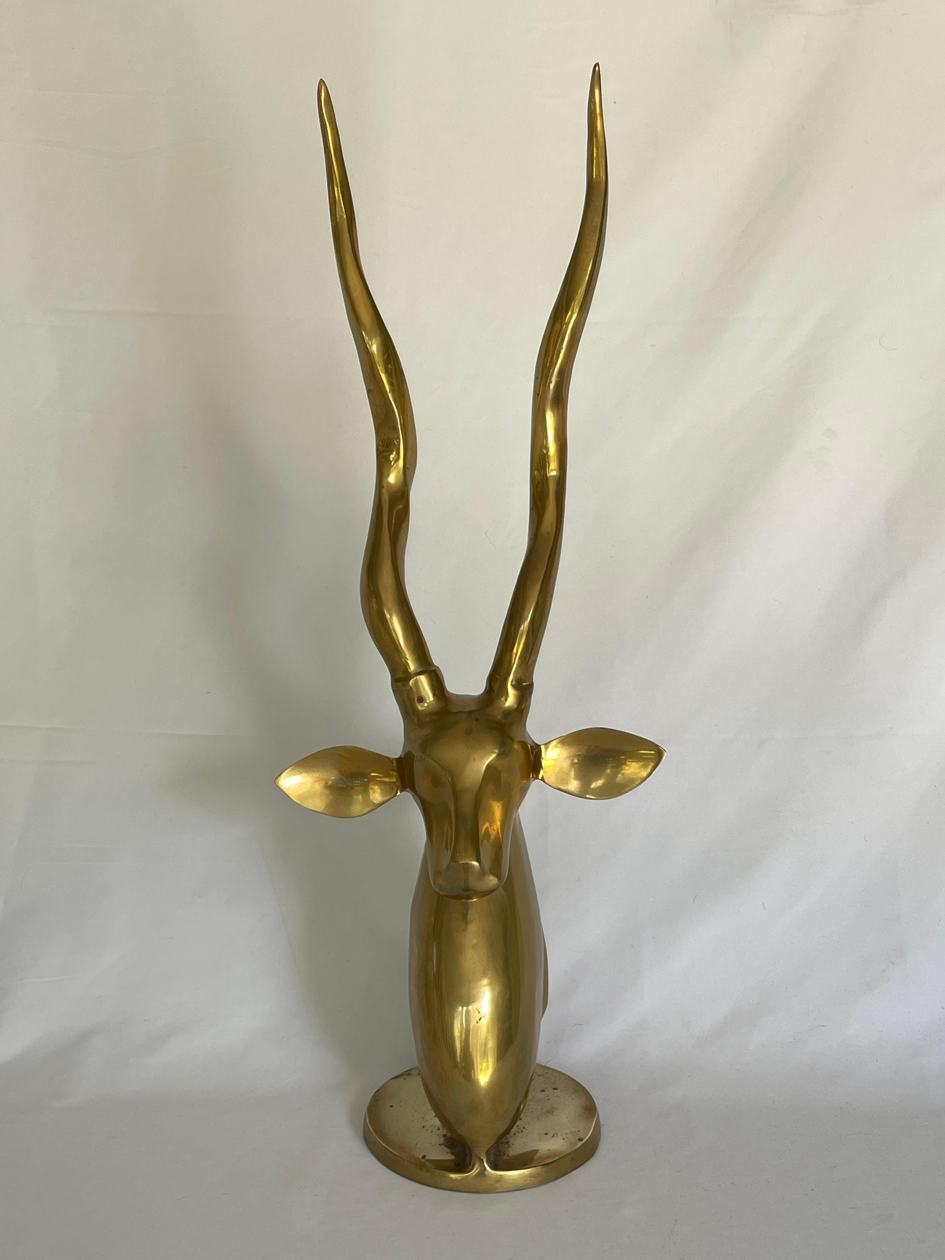 Roberto Estevez  1980's tall polished solid brass kudu sculpture with circular pedestal base.
 
