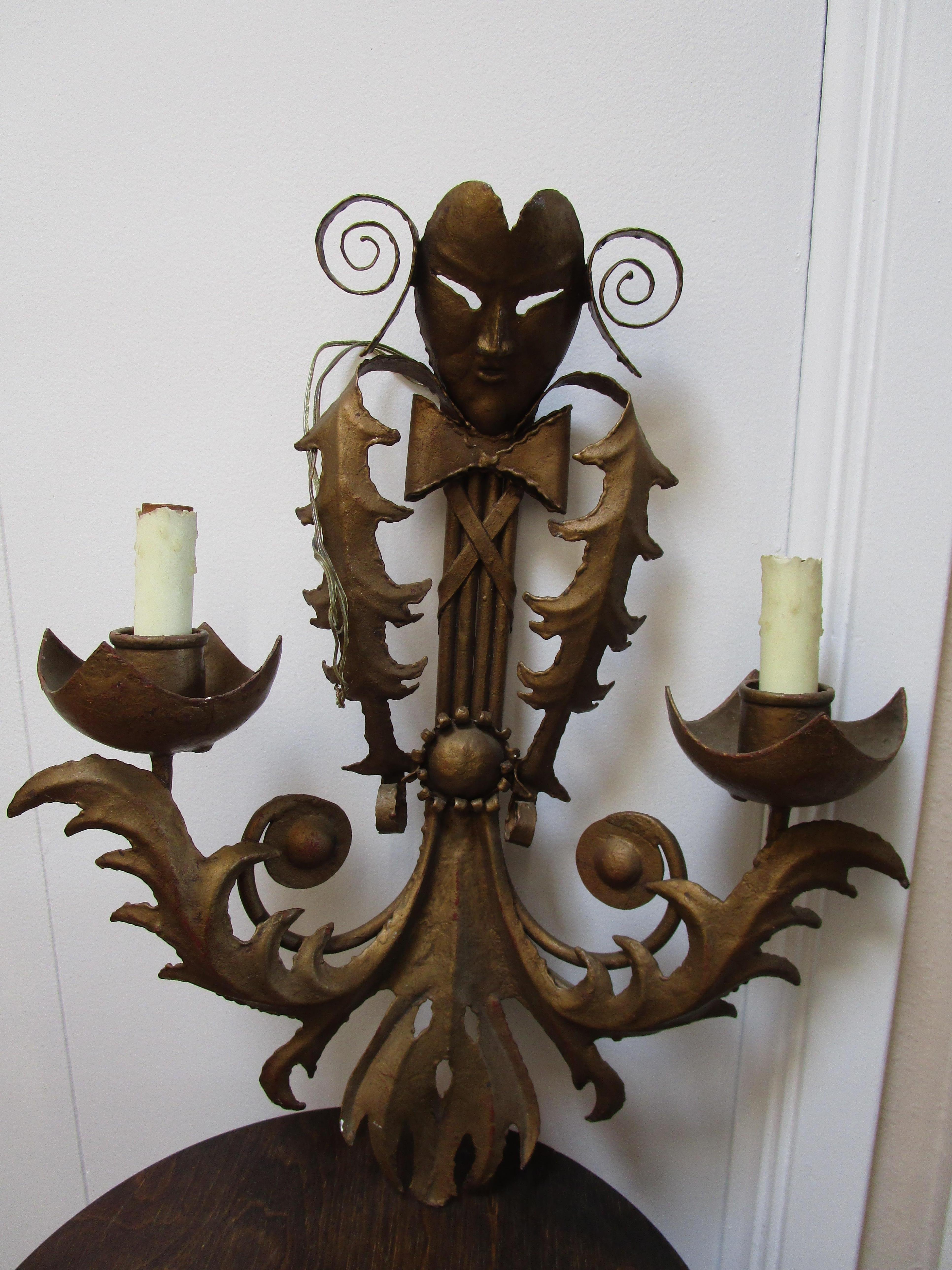 Le decorazioni ornamentali di questa applique in ottone della metà del secolo scorso hanno una bella patina e due candele e luci. Questo pezzo sarebbe fantastico su uno sfondo scuro o su una parete bianca o marrone chiaro. Questa applique è stata