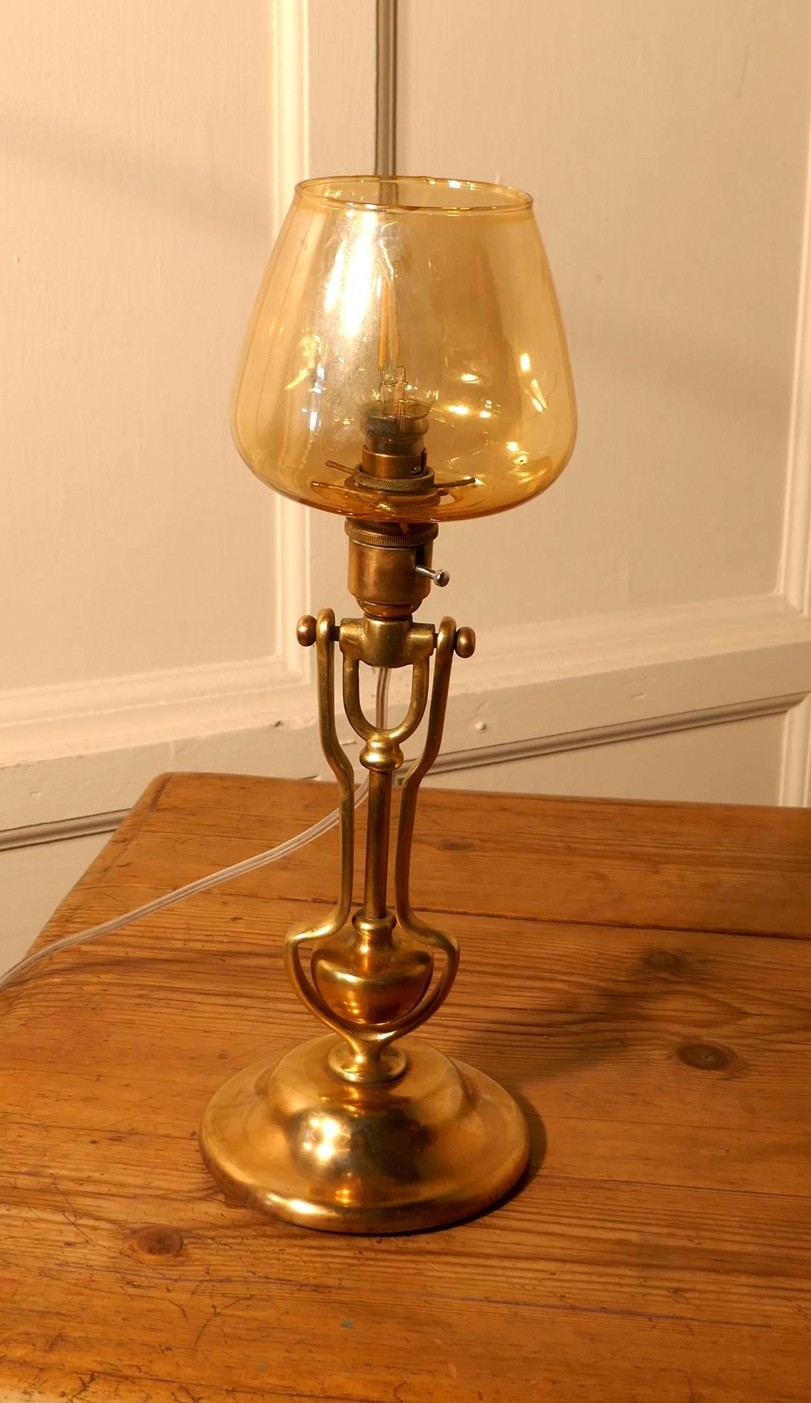 Brass gimbal ships lamp, wall hung or table lamp.

This is a very attractive piece, the lamp originated from a boat, it has a gimbal action which when the boat sways from time to time the original oil lamp would remain upright. The oil lamp has