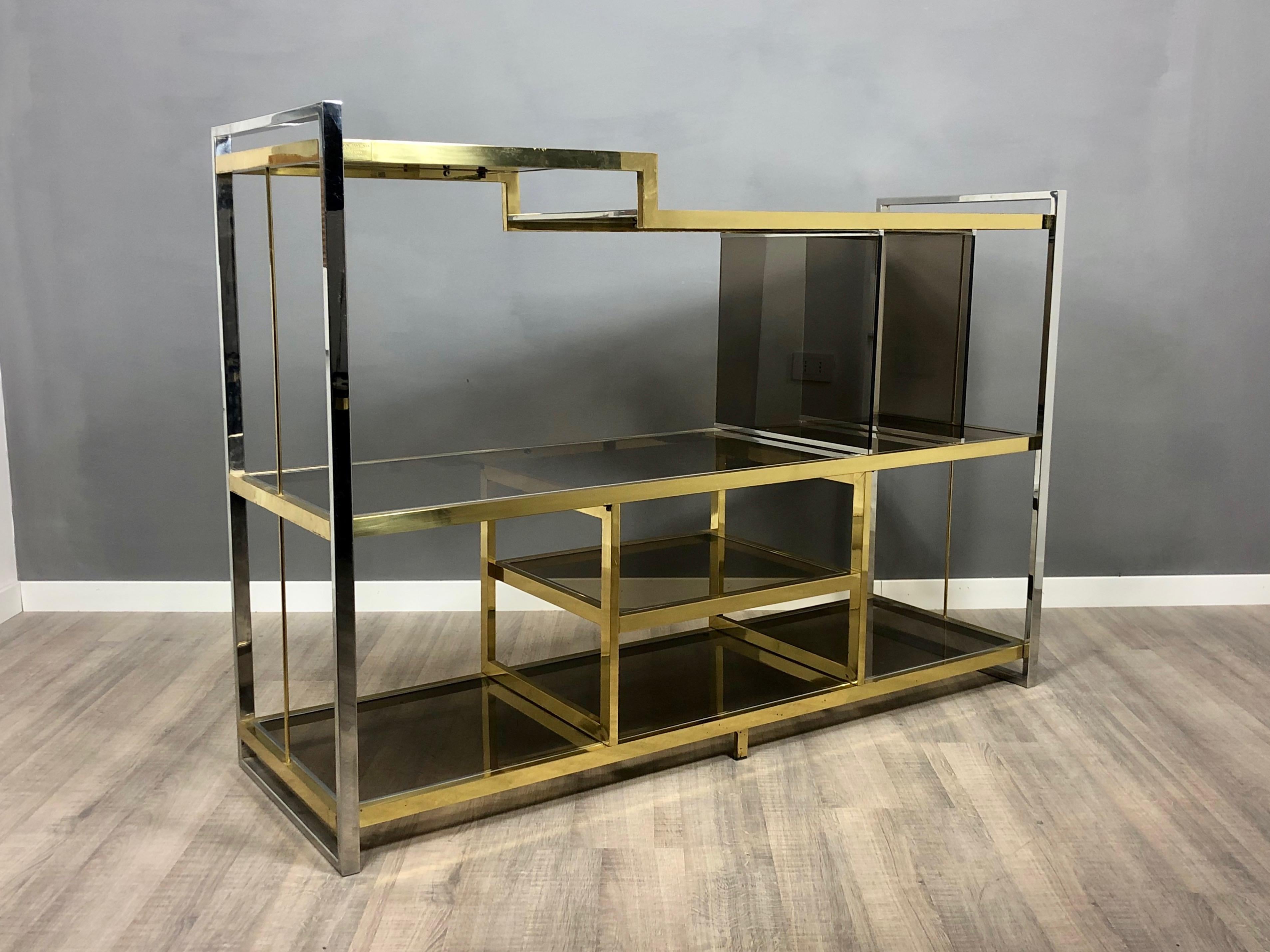 Console/sideboard in brass, chrome and smoked glass. Designed by the Italian Serantoni & Arcangeli for New Ideas Inox, circa 1970s, Italy. 
It has its original target. 
Condition are excellent, light wear due to age and use, as the photos