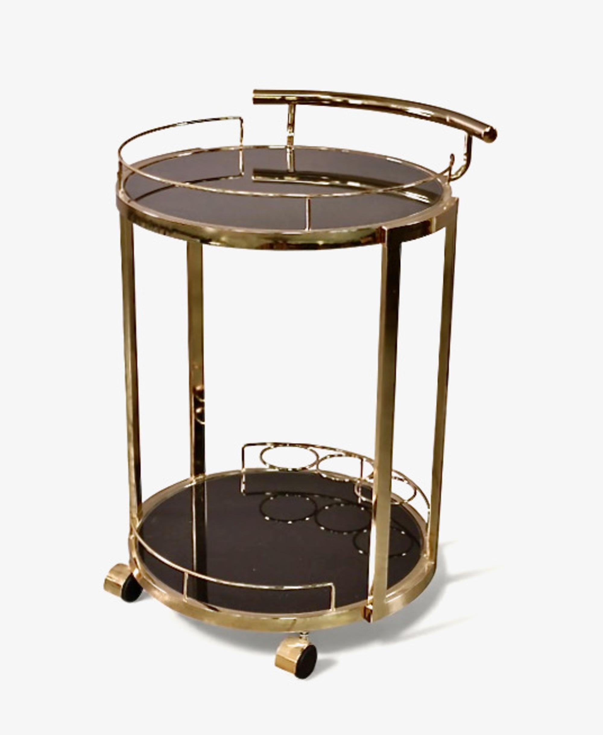 Voici un magnifique petit chariot de bar en verre et en laiton datant des années 1980. Le chariot est équipé d'un support pour trois bouteilles et offre de la place pour des bouteilles et des verres supplémentaires. Le style chic de ce chariot lui