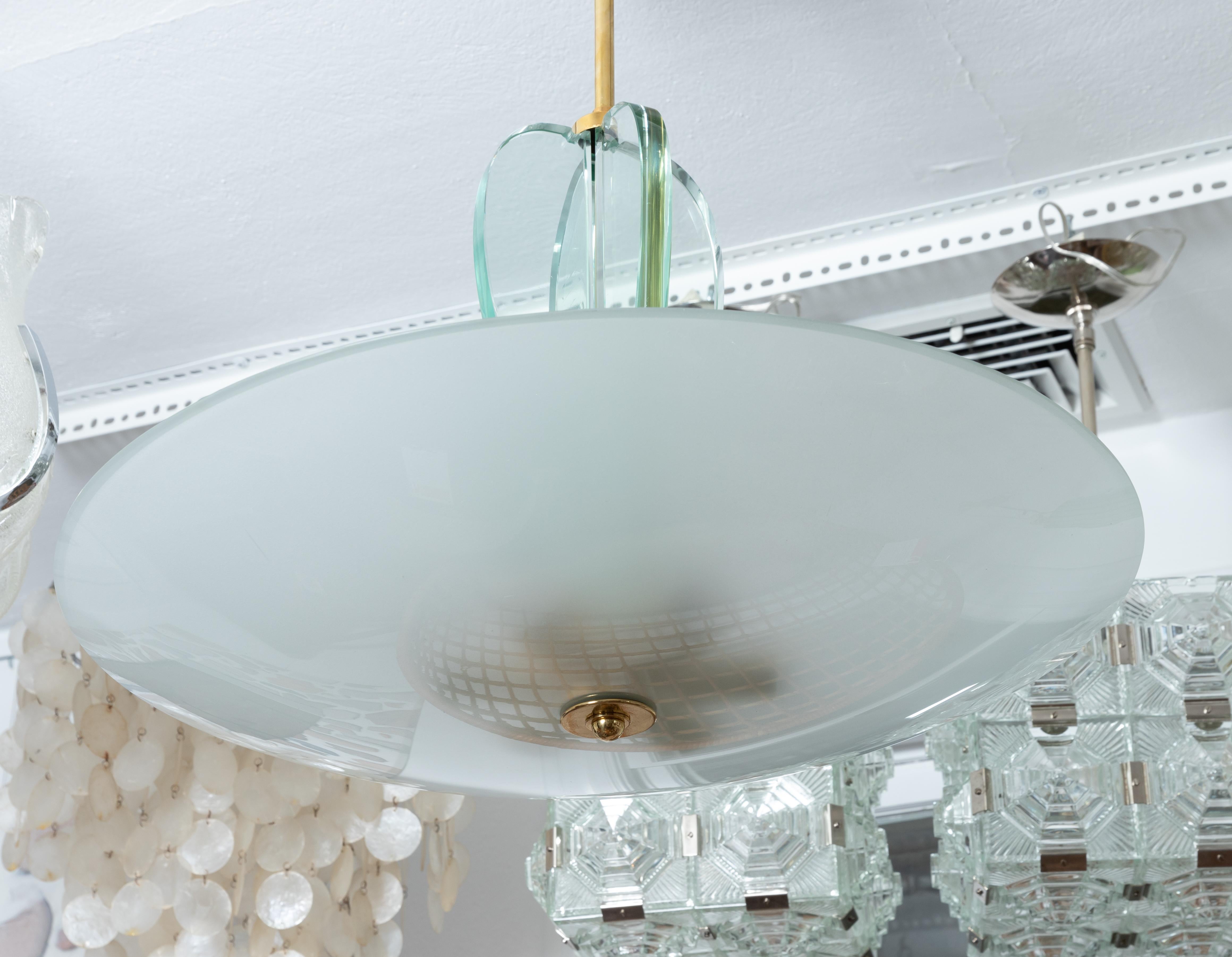 Brass and glass pendant fixture with saucer form frosted glass shade.