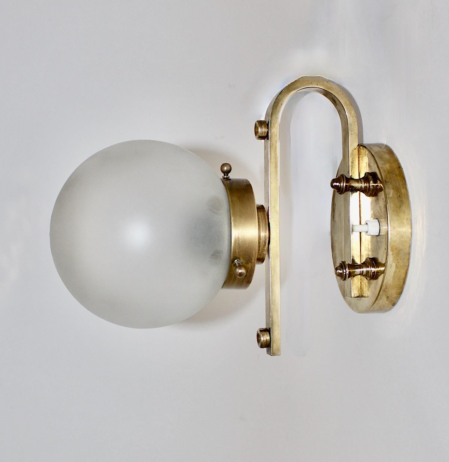A brass glass vintage Art Deco table lam or sconce, which was designed and made circa 1930, Austria.
The beautiful Art Deco lamp shows a brass base with a frosted milk glass shade, both in very good condition with signs of age and use. Also the