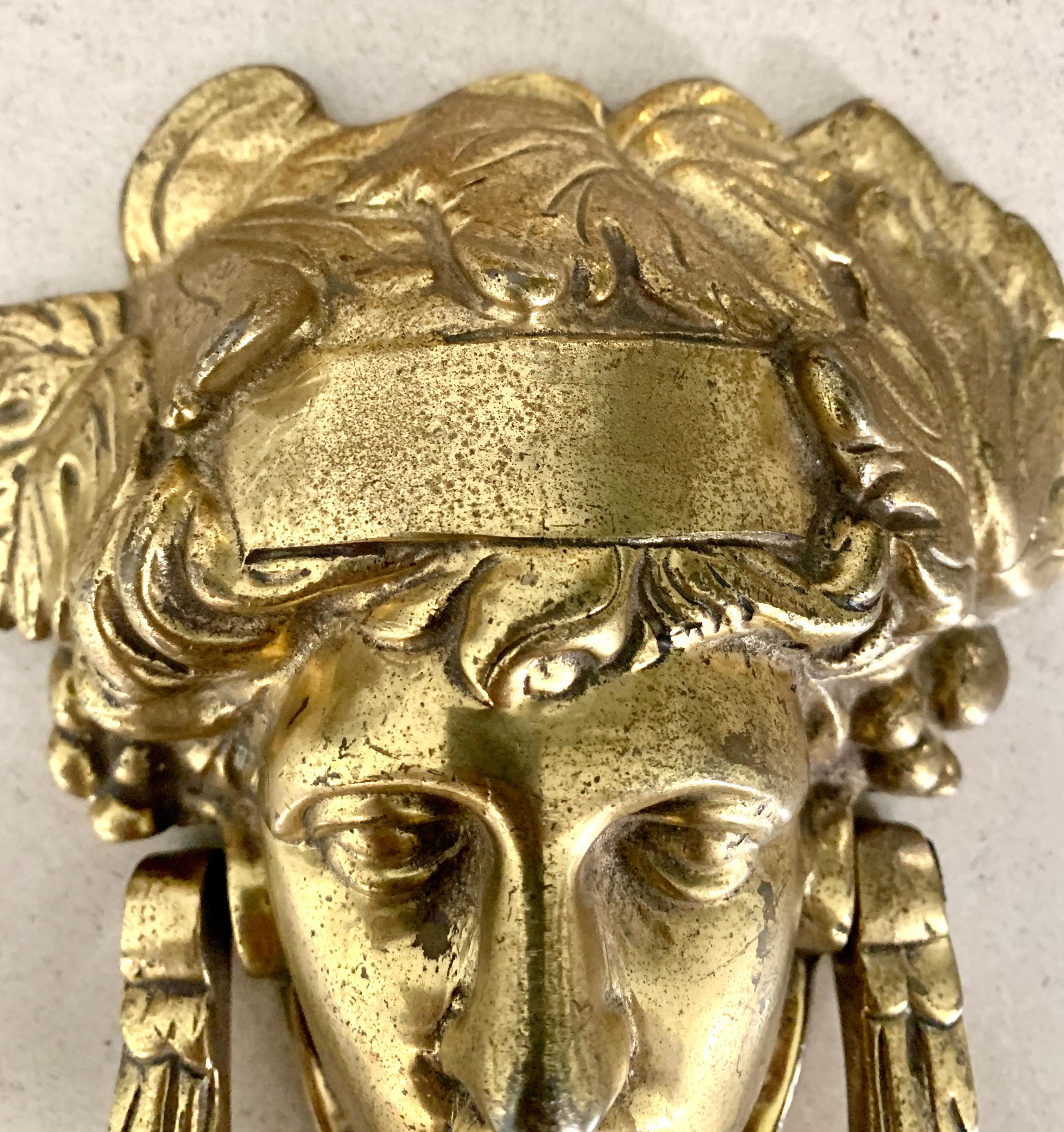 A large brass door knocker in the image of Athena. Athena is the Goddess and protector, making this a very appealing knocker for your front door. Vintage Brass in great condition. The image is surrounded with leaves, ivy and foliage - a great