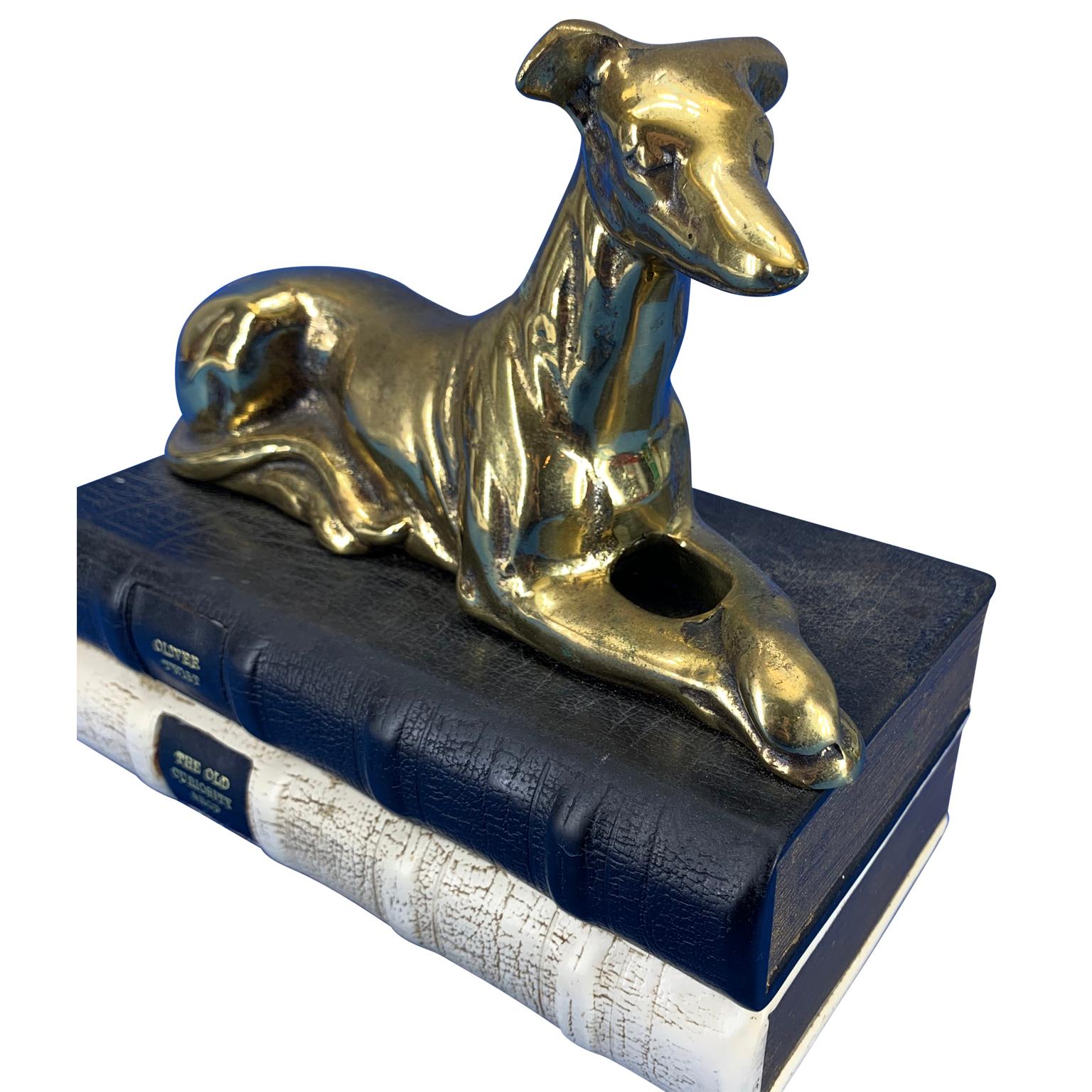 Brass greyhound table lamp by Thomas Blakemore, Walsall, England

Greyhound is lying on two ceramic books, Oliver Twist and The Old Curiosity Shop.
