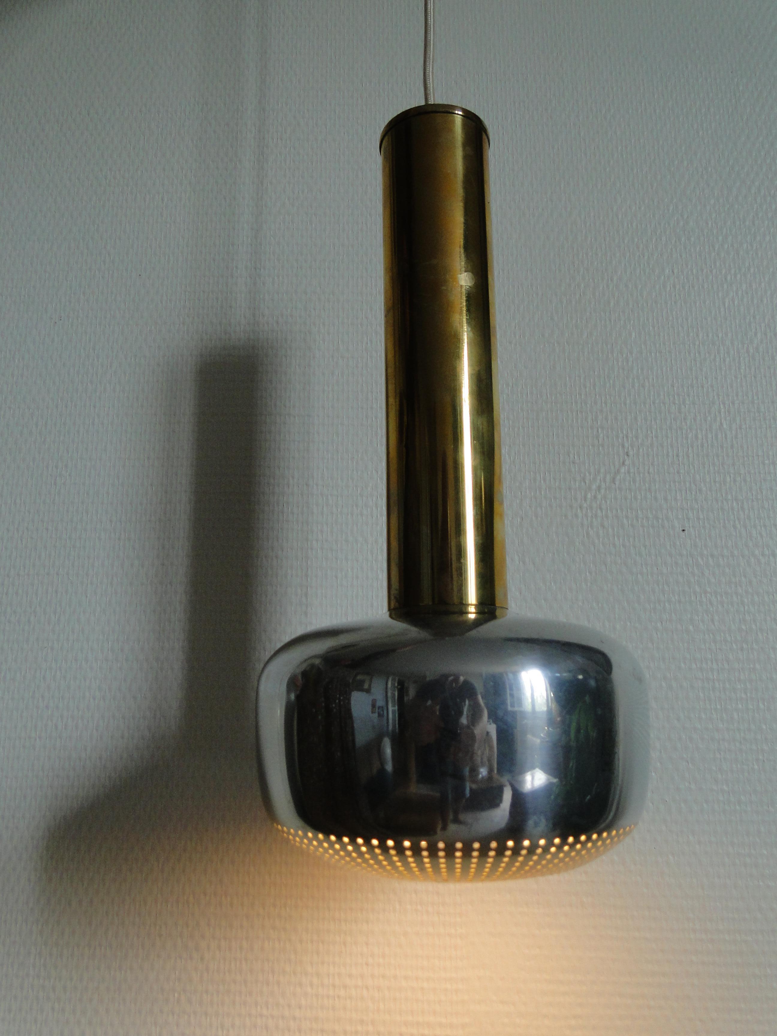 Brass Guldpendel suspension designed in 1956 by Vilhelm Lauritzen for Louis Poulsen.

The perforated metal reflector at the bottom of the lamp is in white brass, the long part is in gold brass. The first part of the electrical wiring is cleverly