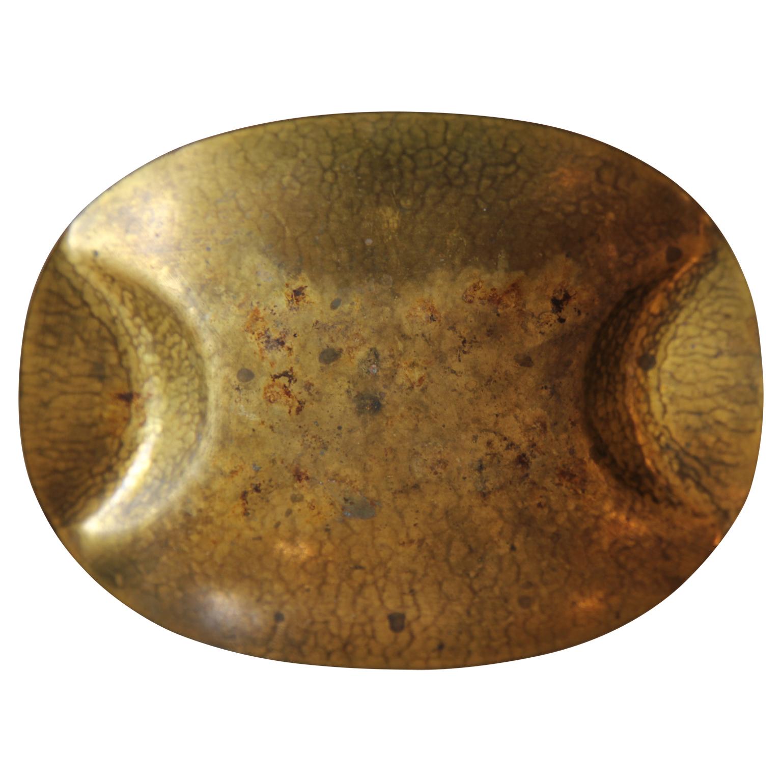 Brass hammered oval dish with two indentions on either side. The dish is stamped by the artist and numbered 998. Hayno Focken was a German modernist known for making hammered table accessories.
