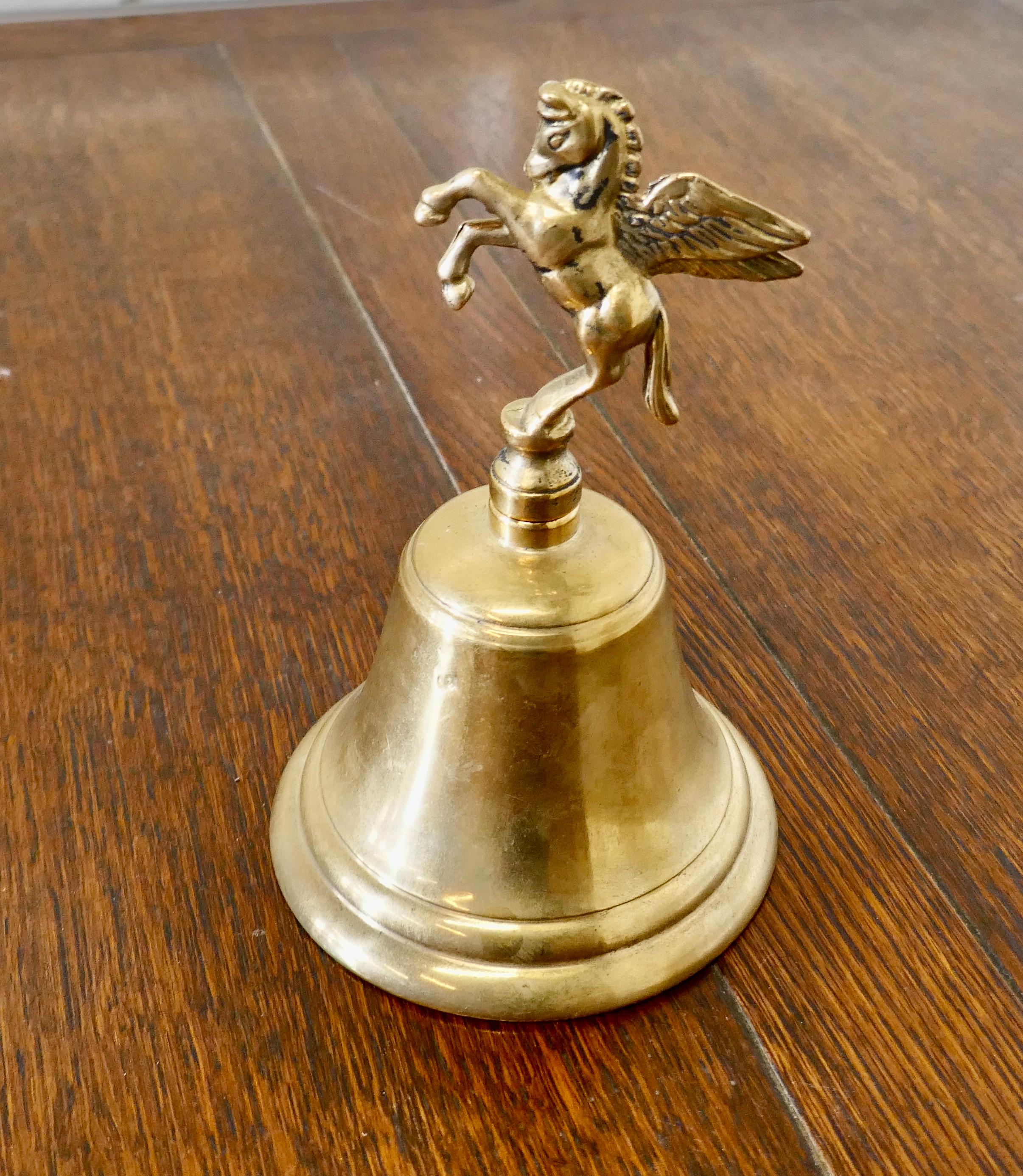 Brass hand bell with Pegasus handle 

Great little piece with a delightful ring, the bell is decorated with Pegasus making the handle
The bell is 8” high, and 5” wide and deep
TNV229.