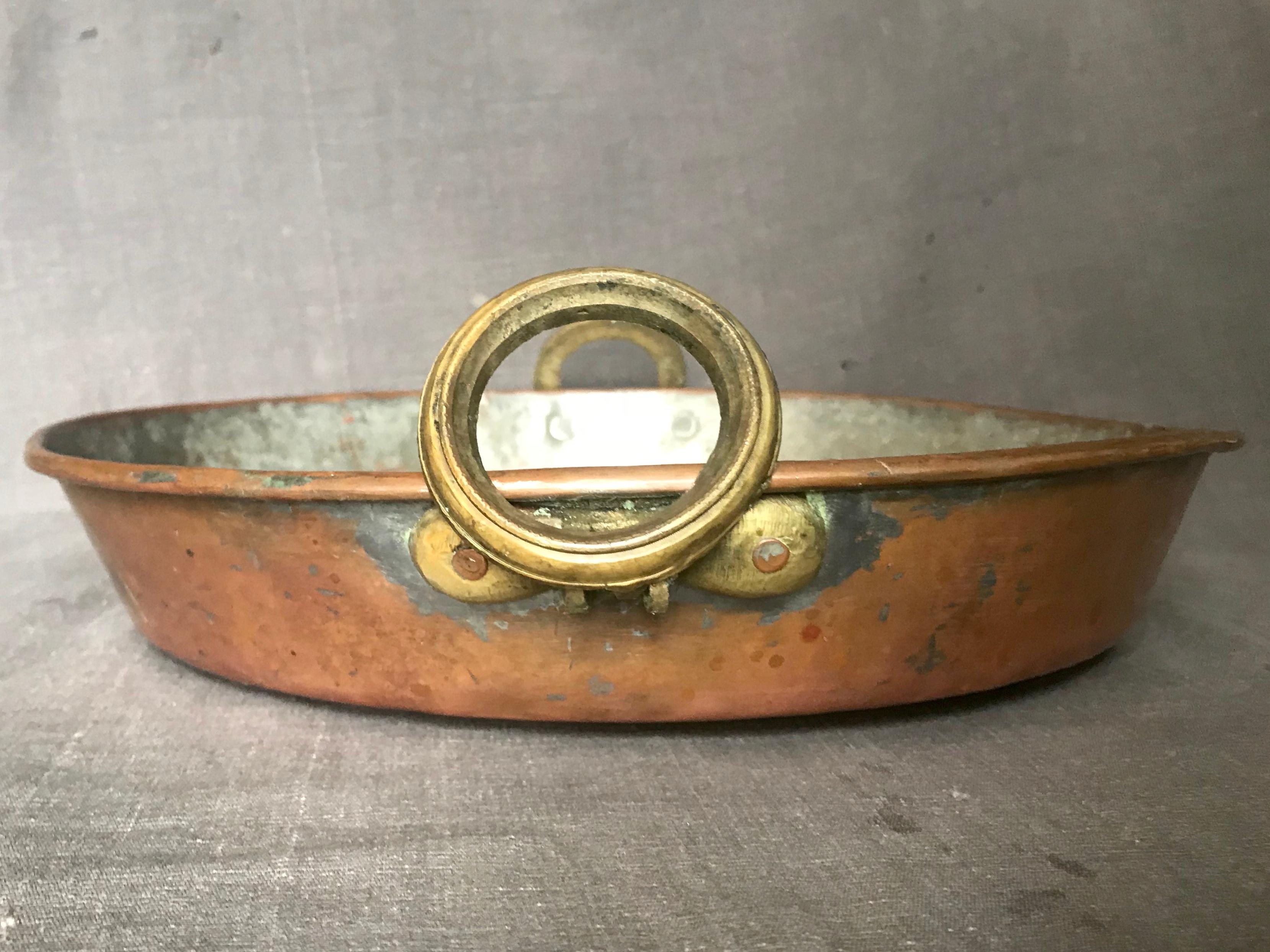 Brass handled copper pot / braising pan. Large antique copper pot / braising pan with copper plating and brass ring handles. Possibly French. Continental, late 19th century.
Dimensions: 19” width handle to handle x 2.75” height, 14.25” diameter.