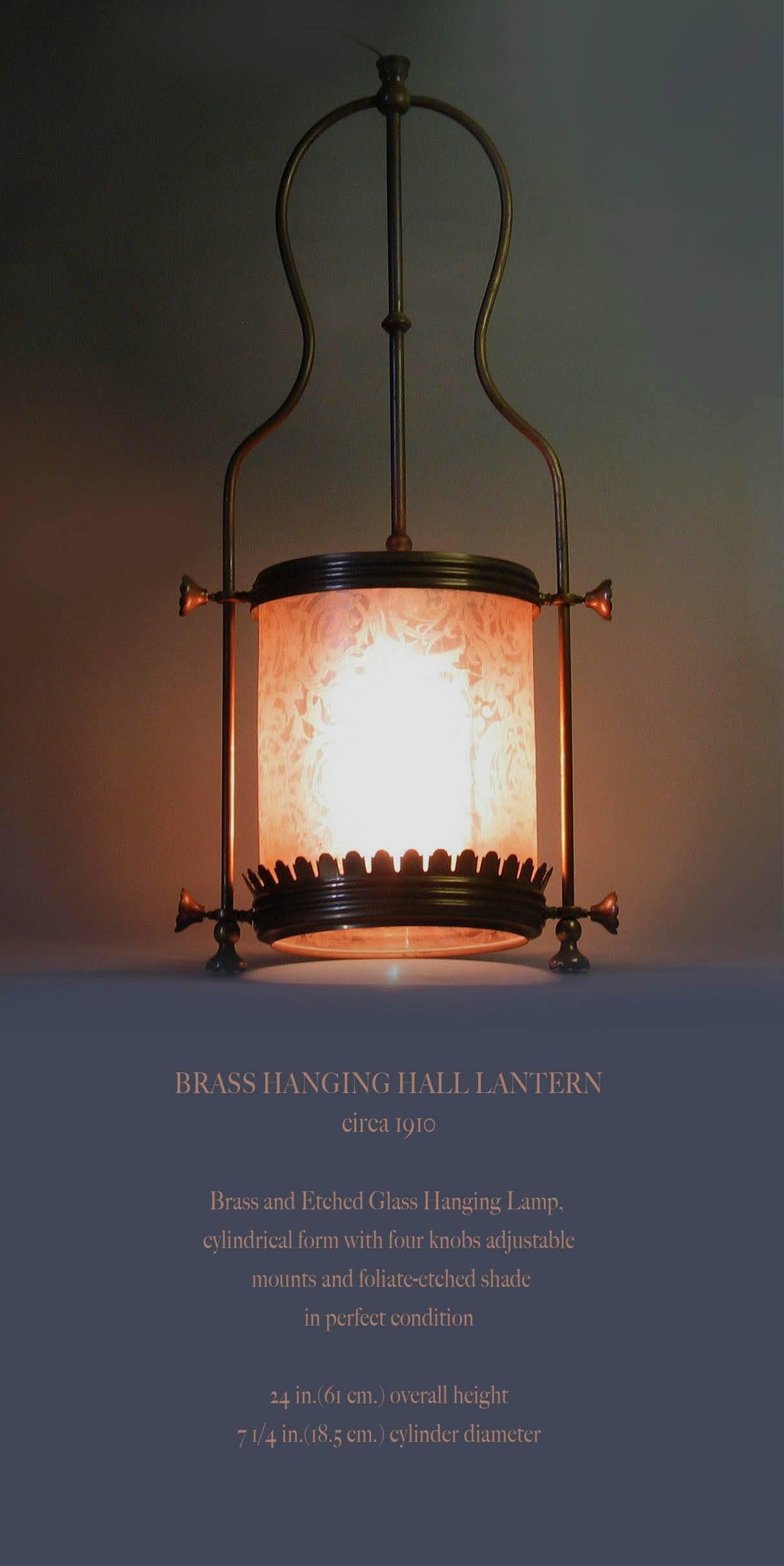 A brass hanging hall lantern, circa 1910, a brass and etched hanging lamp, cylindrical form with four knobs adjustable mounts and foliate-etched in perfect condition. The hanging lantern measures 24