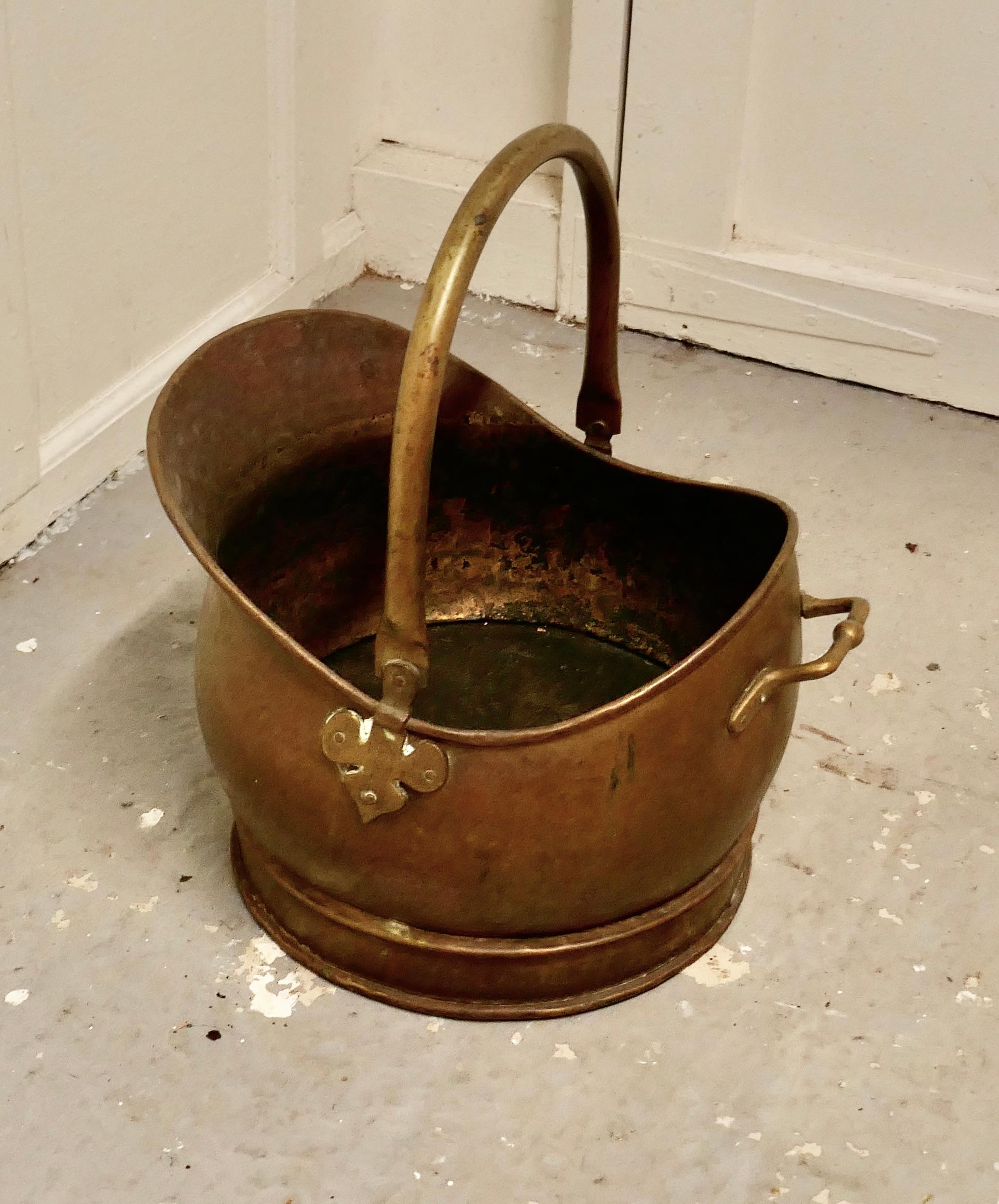 Brass Helmet coal scuttle 

This bucket is a very attractive helmet shape, it is made in beaten Brass with riveted hooped brass handles
The Scuttle is in good used condition, it has a good patina, lots of character and is ready to go to work and