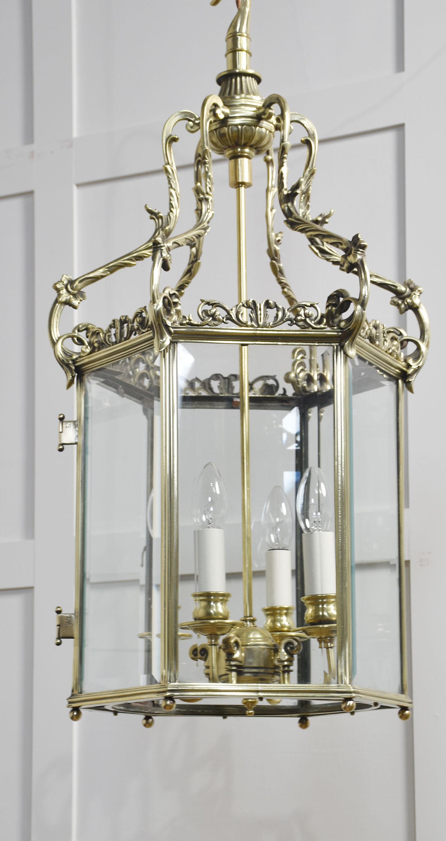 Hexagonal brass hall lantern of George III style with six scrolled ribs and glazed panels enclosing four lights. The lantern has been rewired.
Dimensions
Height 31.5 Inches
Width 16.5 Inches
Depth 14.5 Inches