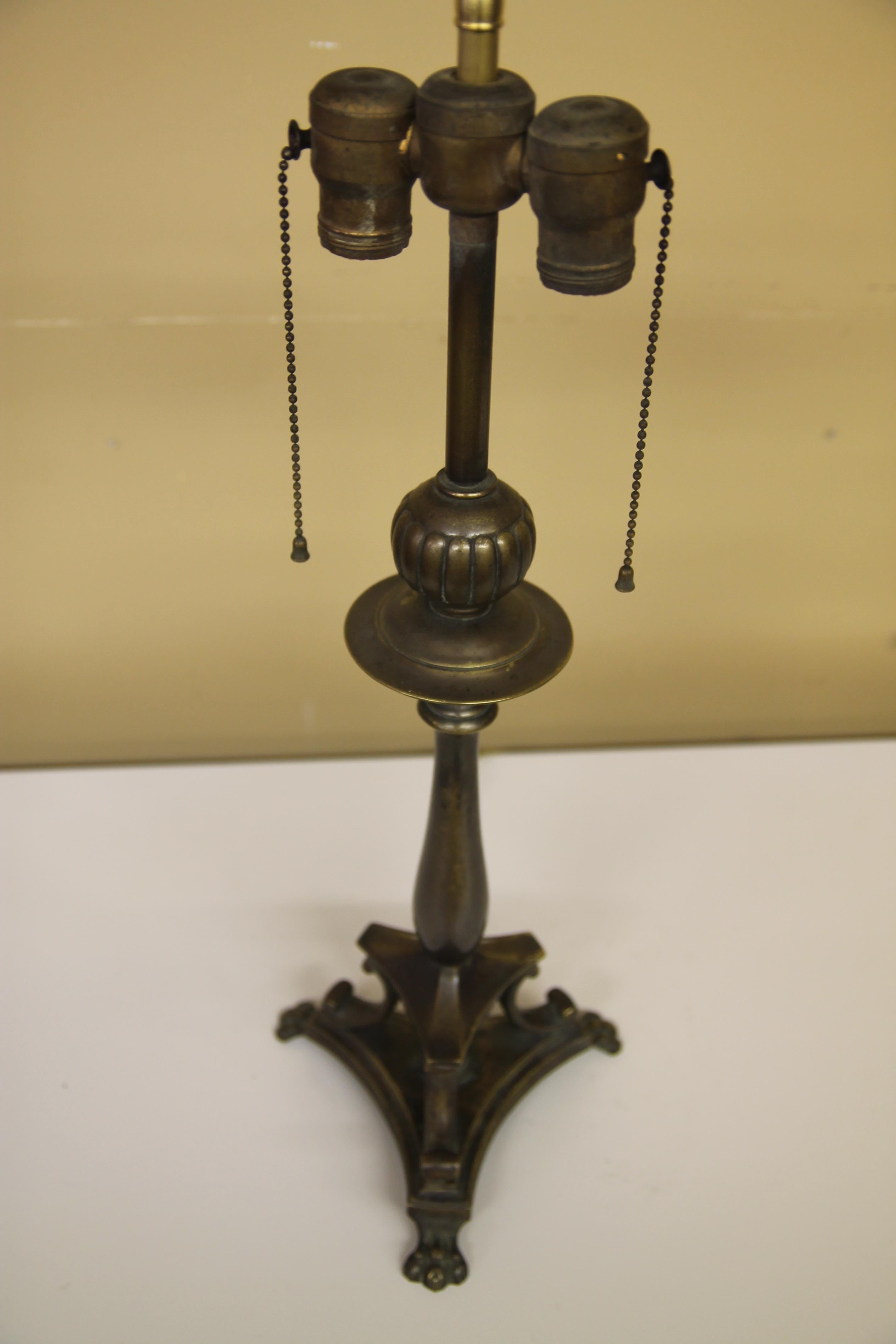 Great brass lamp in the Hollywood Regency style. Lamp looks to be from the 1940s. Has wonderful claw feet with nice patina.