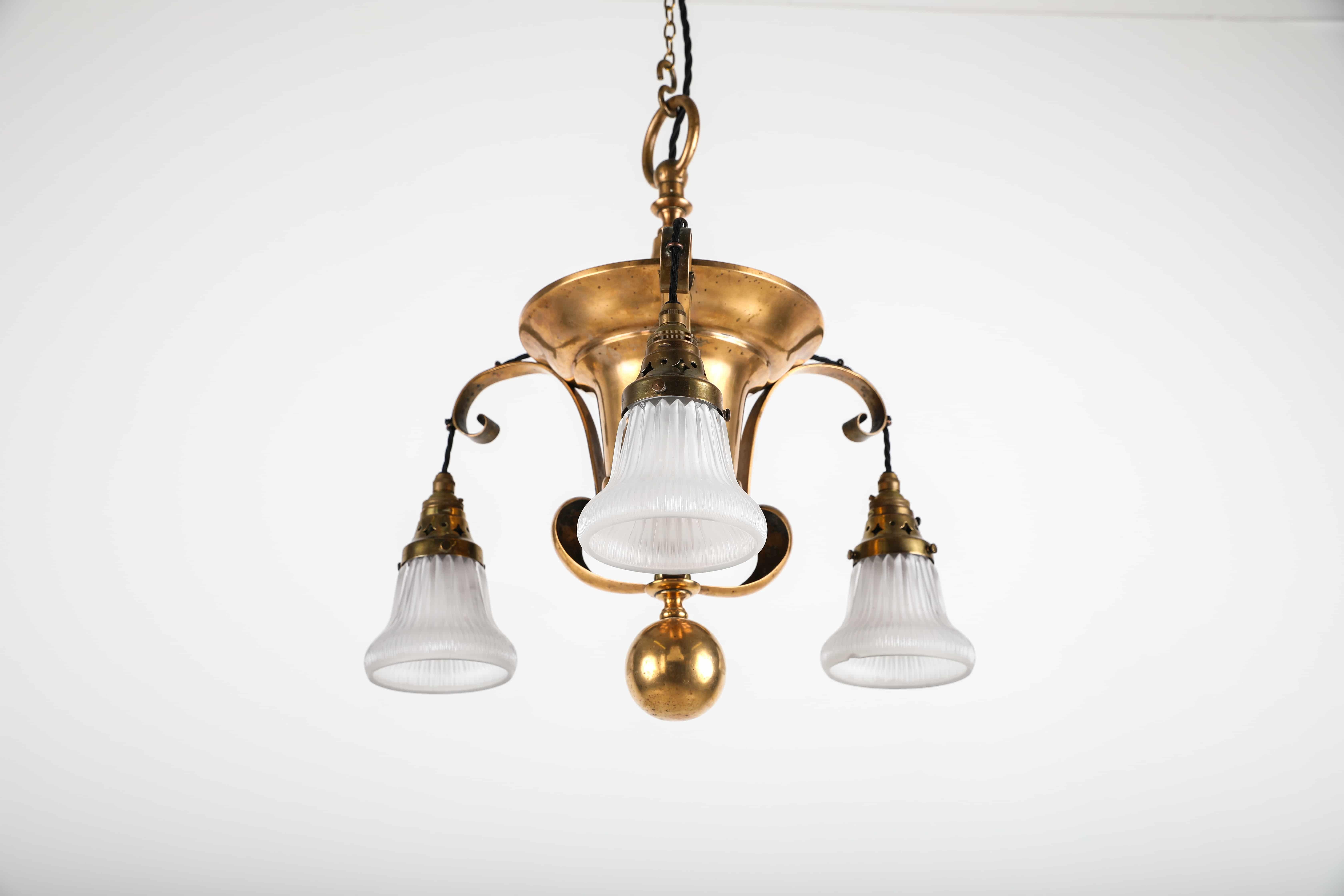An incredible brass bodied chandelier with three perimeter Holophane shades. c.1920.

Of beautiful form, made up of early brass fitting - possibly made by Simplex - with a trio of very rare Holophane 'Residence Reflectors' with a satisfying and
