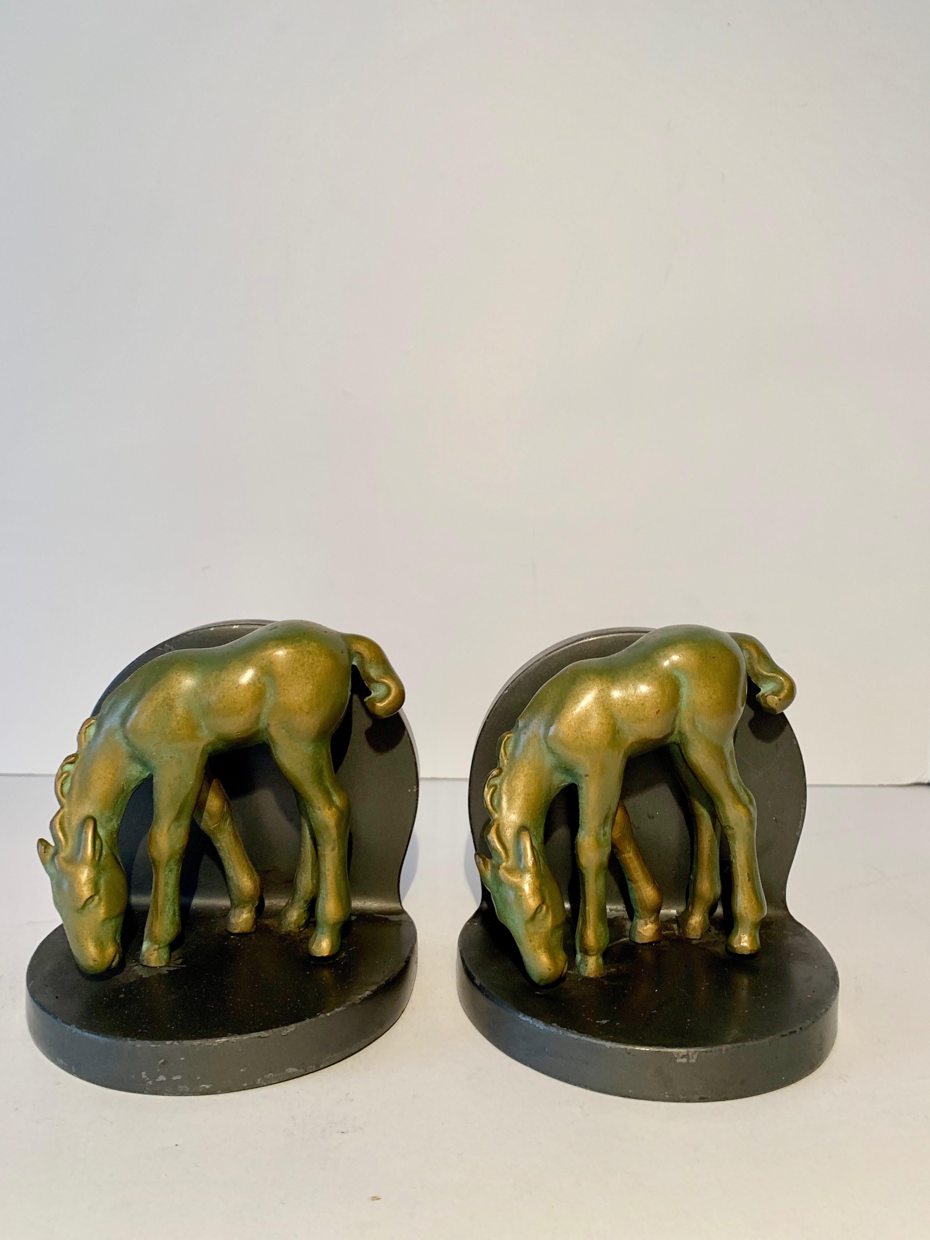 A handsome pair of brass bookends on a metal base. Beautifully patinated brass horses grazing. Perfect for the Childs room!