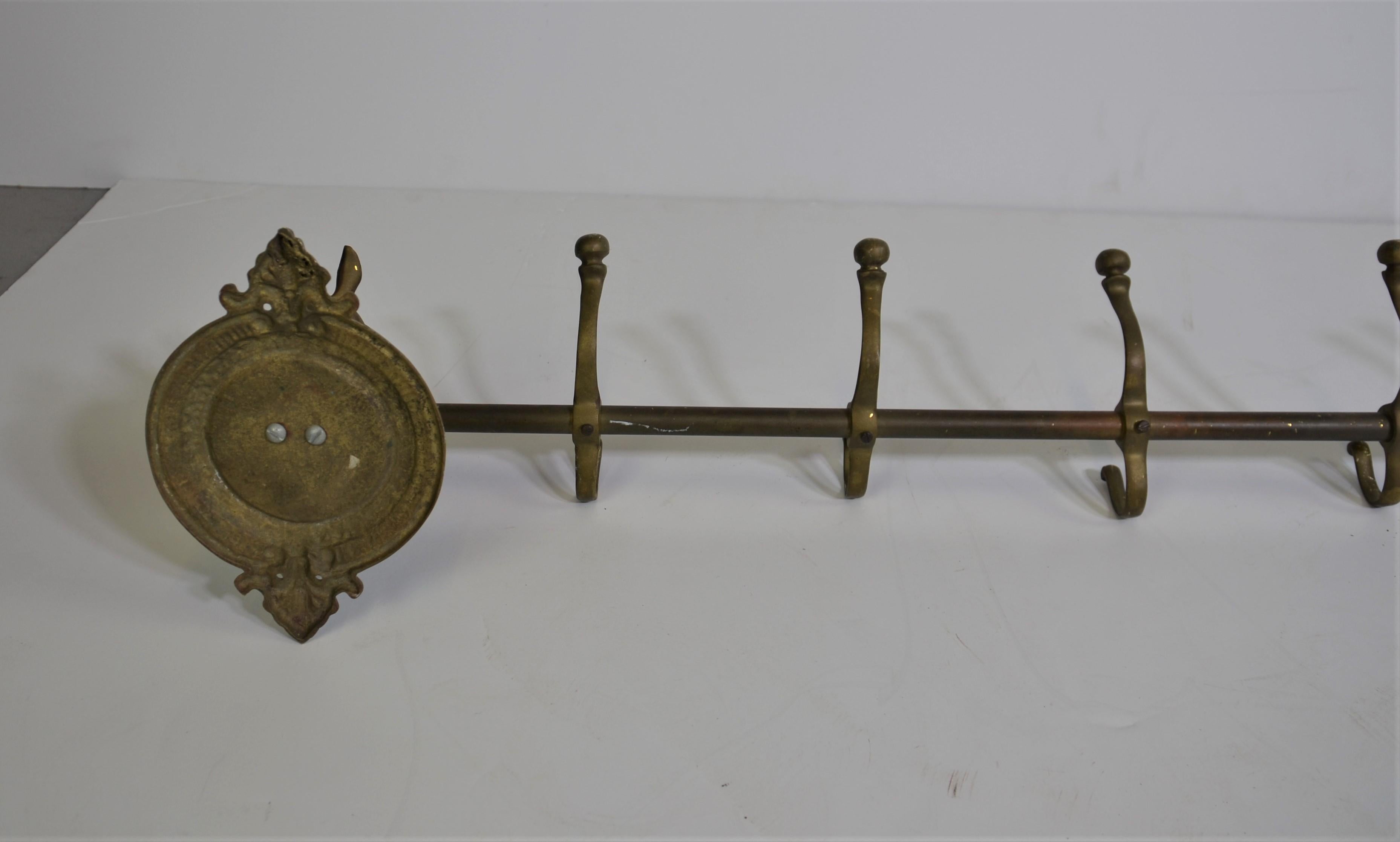 Brass coat rack with a horse head on each end.